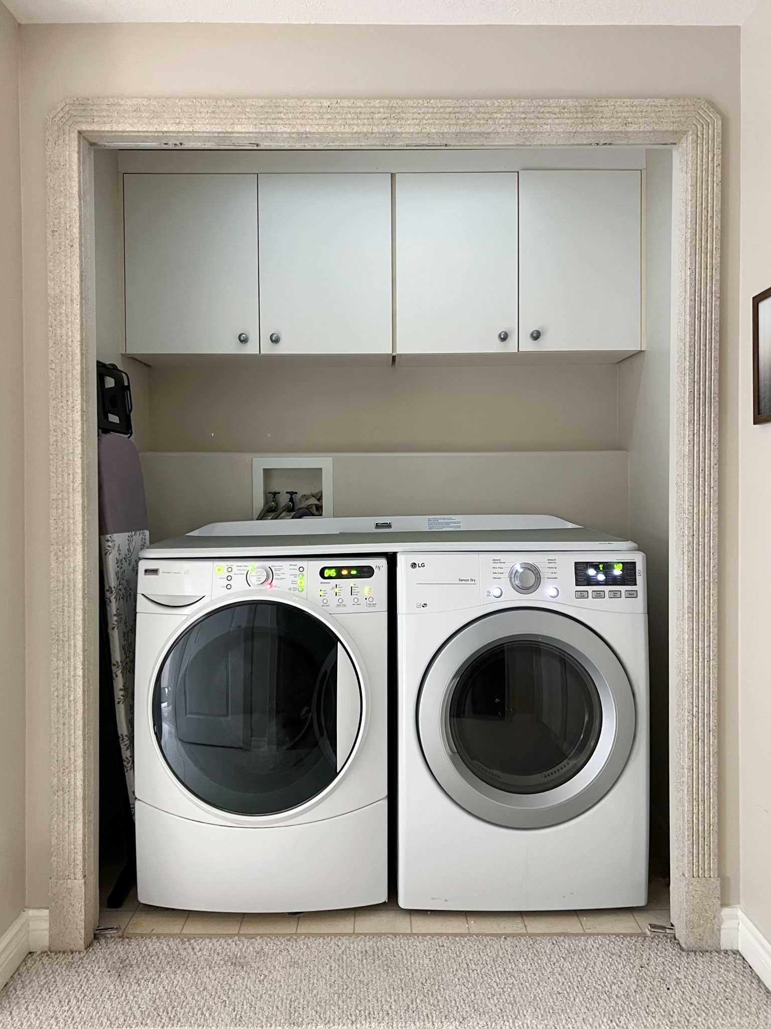 closet with some white cabinets and washer and dryer below