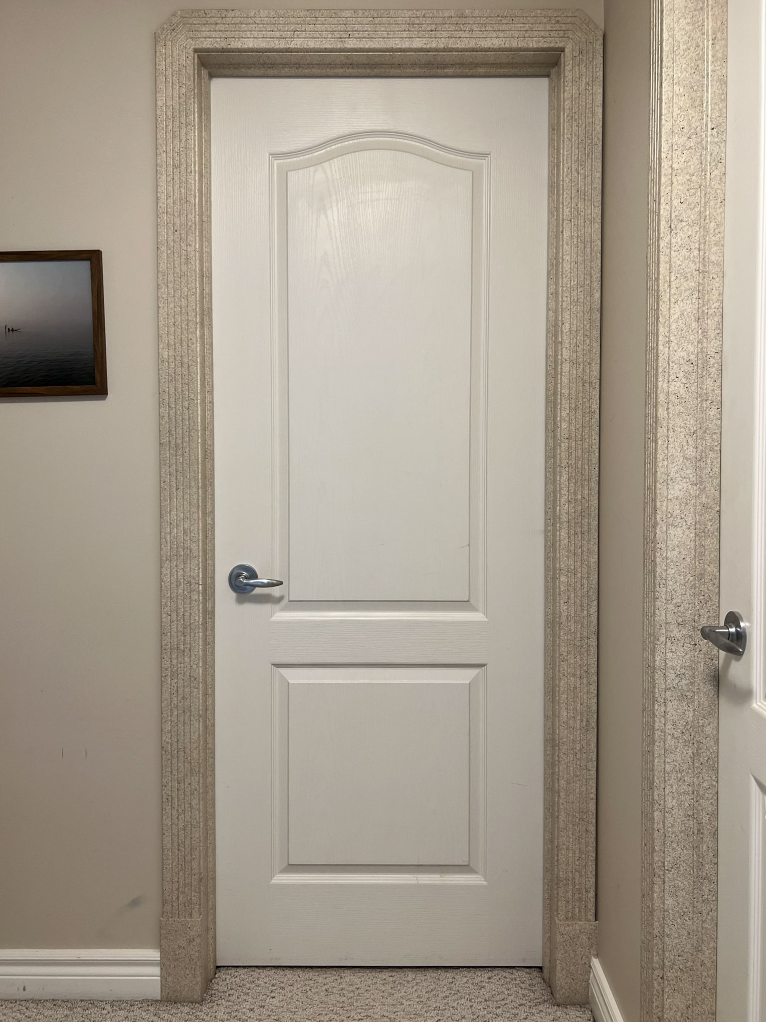 plain white door with textured beige trim and beige walls