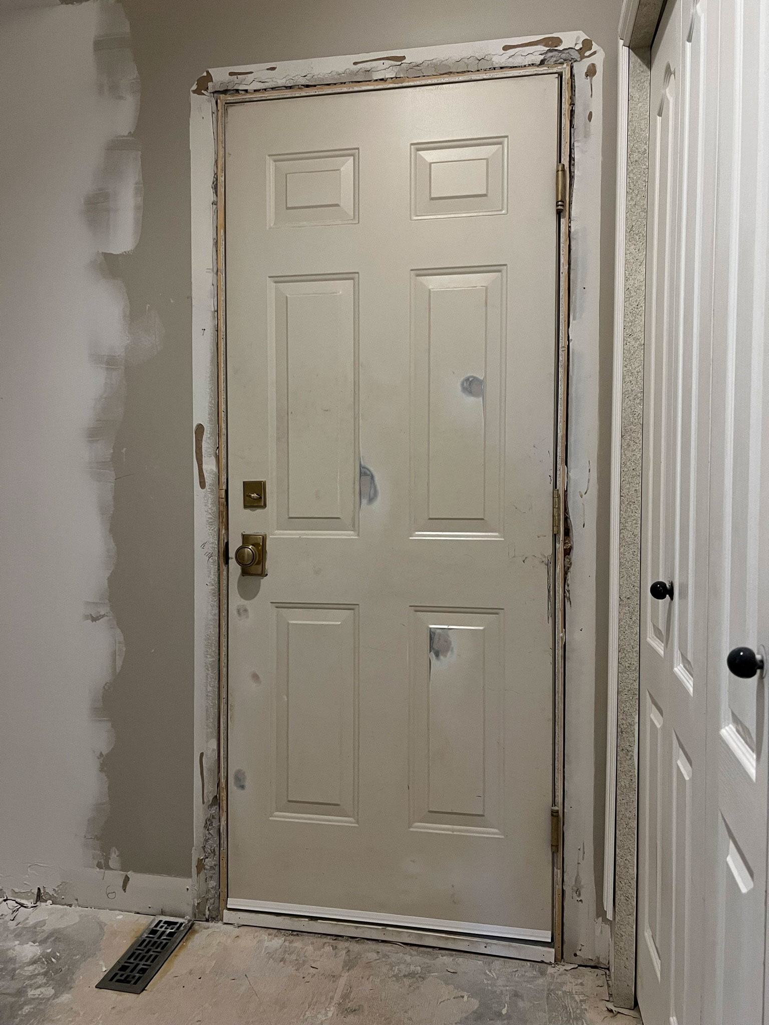 door with patches and no trim and rough drywall, with door opening on the left