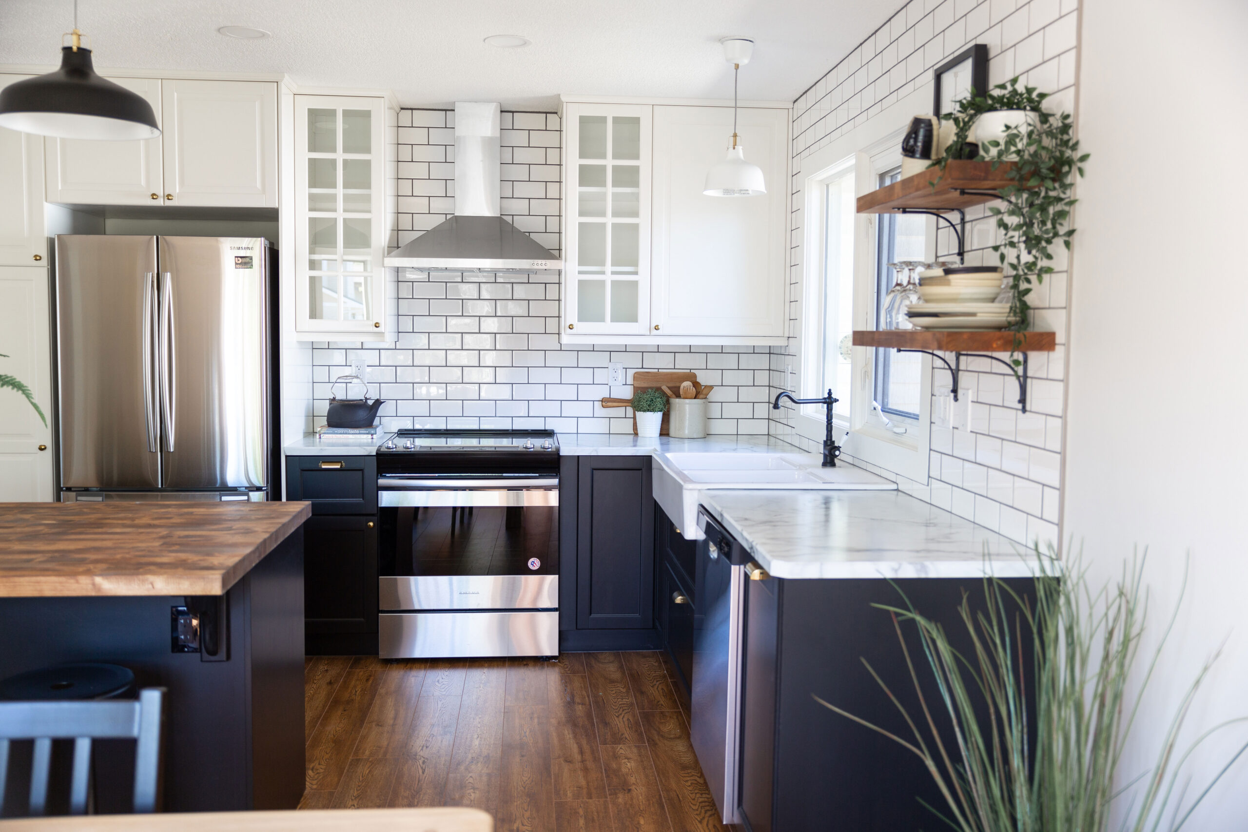 kitchen with black lowers and white uppers and subway tile, cabinets on uppers going straight into the wall