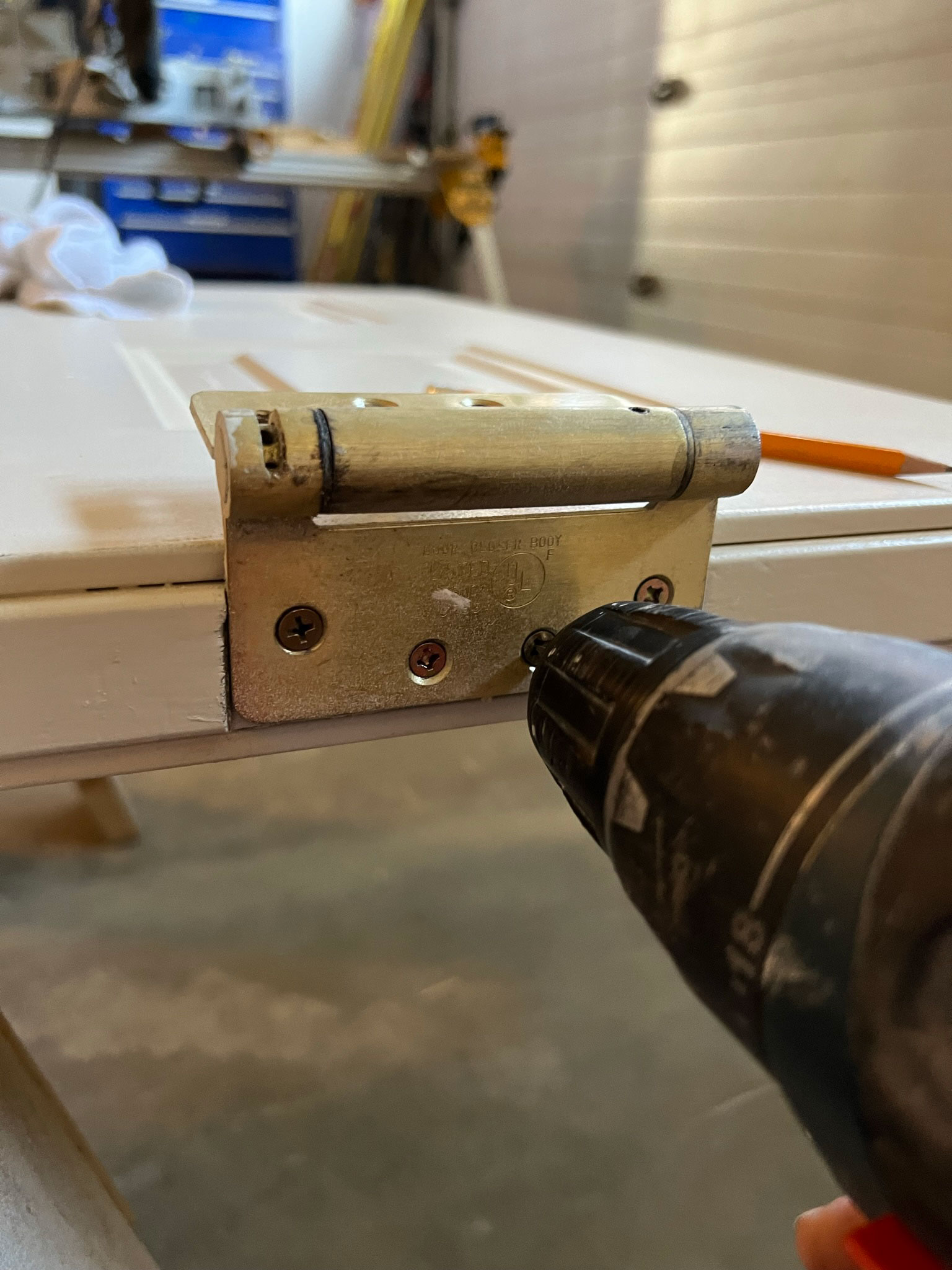 Screwing hinges in with the pin side up using a drill