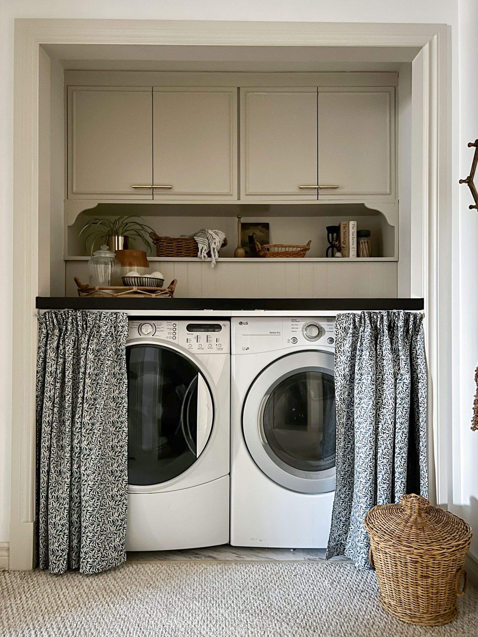 laundry closet, skirted countertsop with curtains open. Cabinets above with an open shlef, edgecomb grey