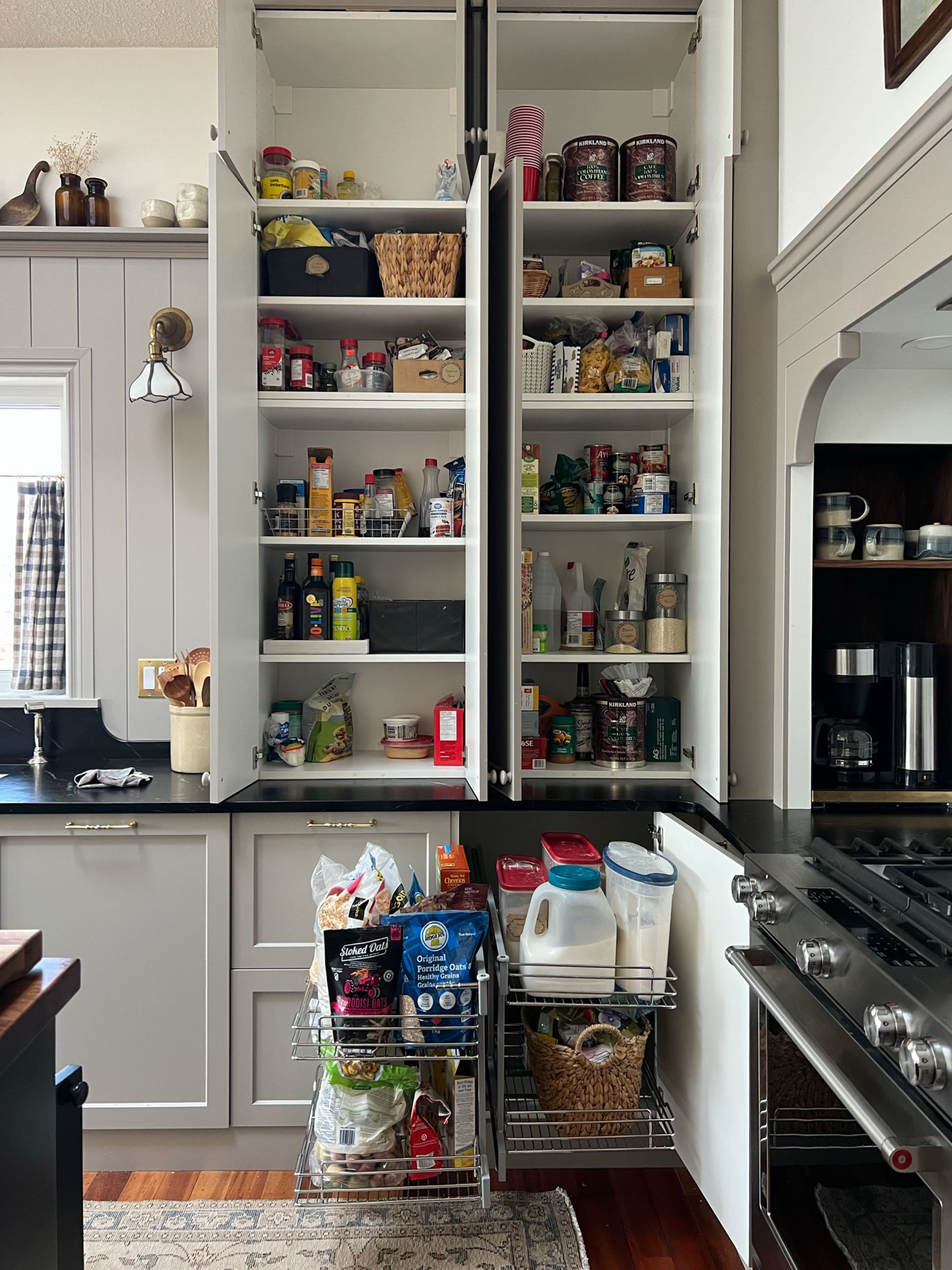 kitchen with cupboard doors all open to show the storage inside and the corner pull out pulled out