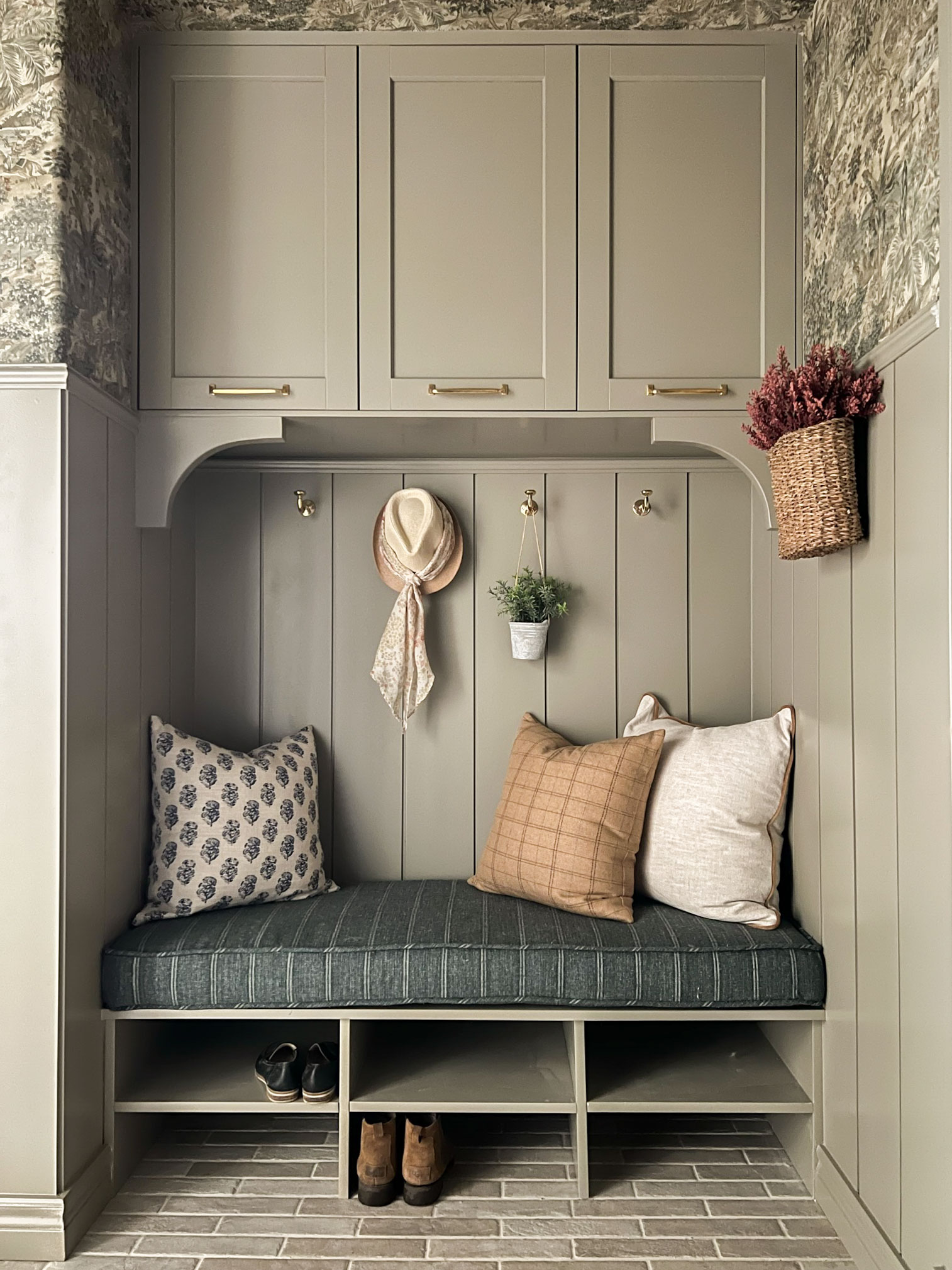 Mudroom bench seat with cabinets above, shiplap and bench cushionw ith shoe shelves below 