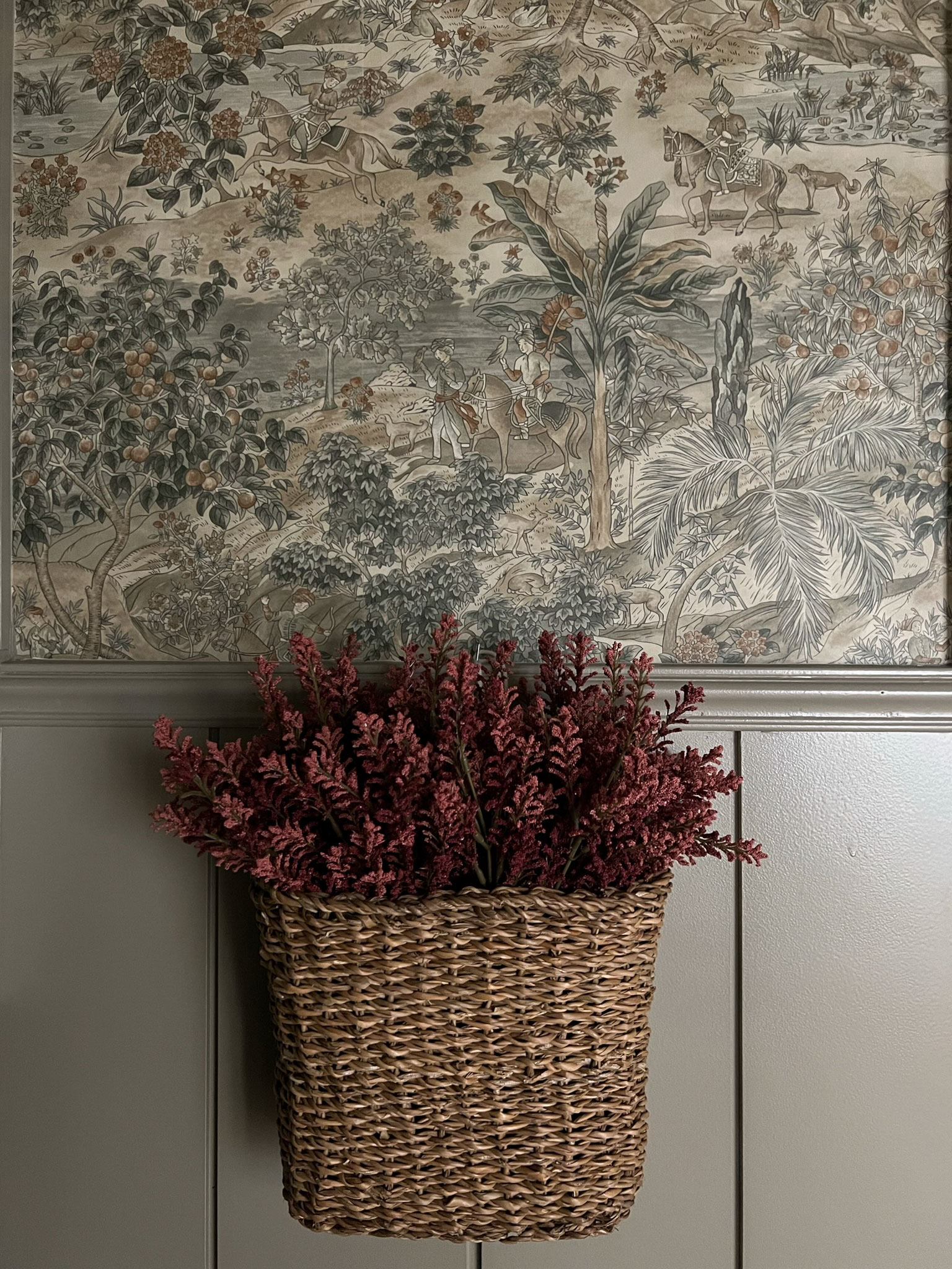 close up of scenic wallpaper with basket hanging from wall with flowers in it