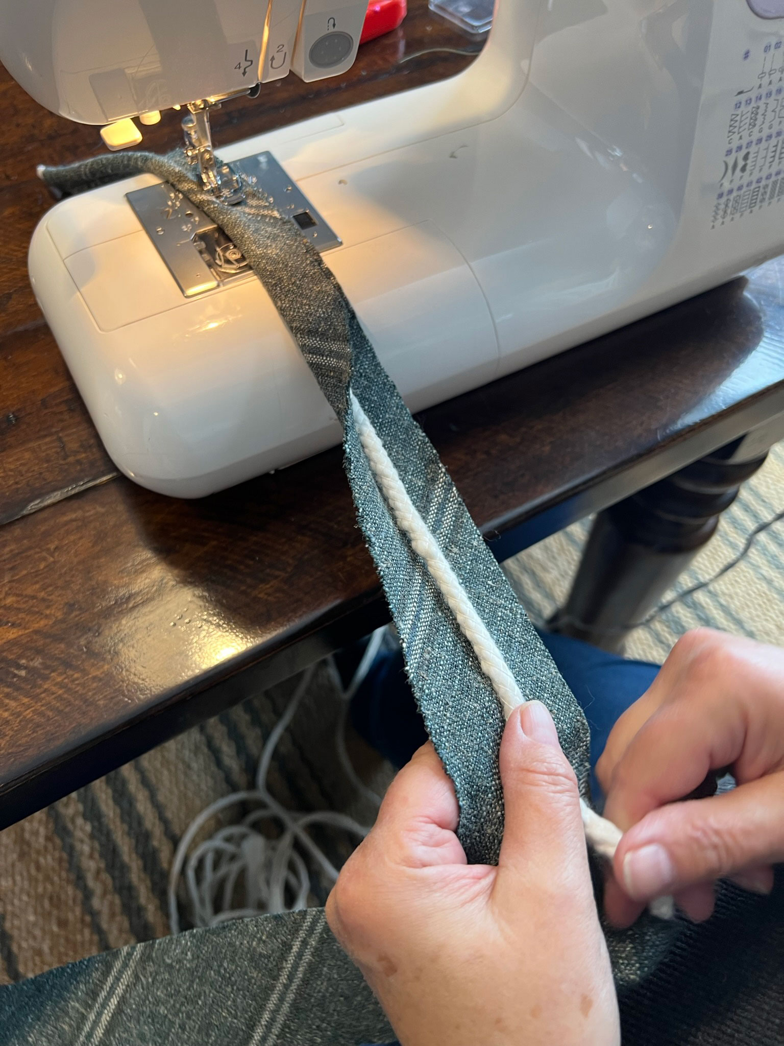 folding a strip of fabric around cording and sewing 