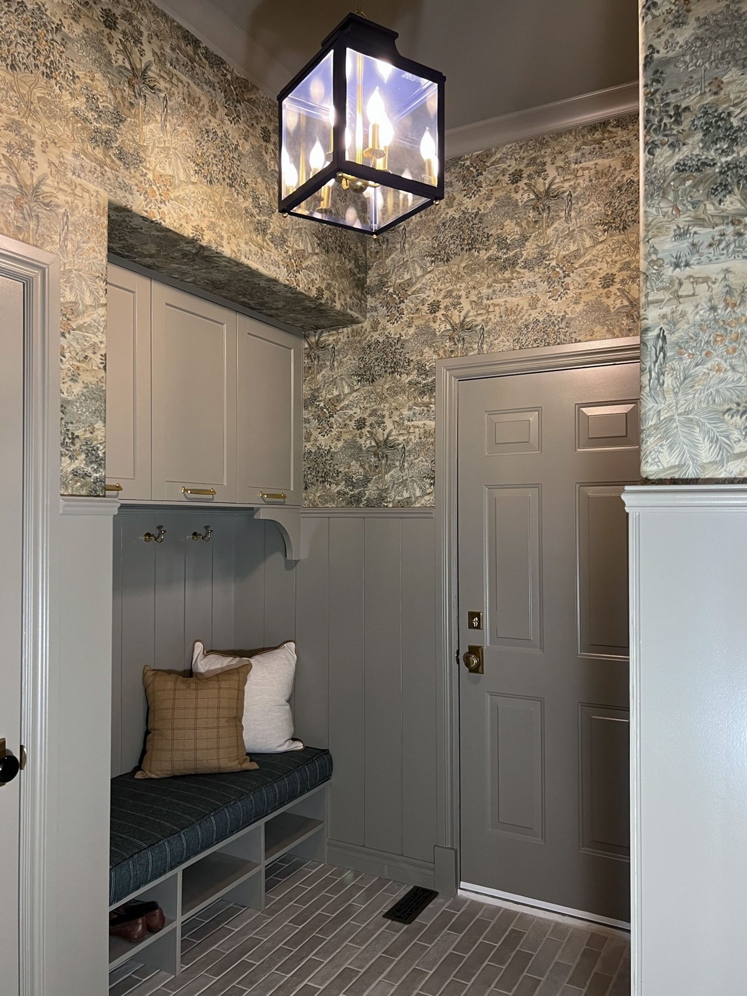 lantern with light on, blue lantern, mudroom with wallpaper and shiplap