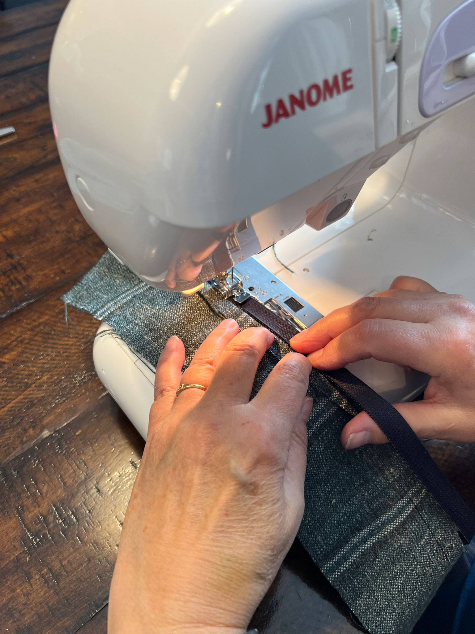 woman usuing a sewing machine to sew along a zipper