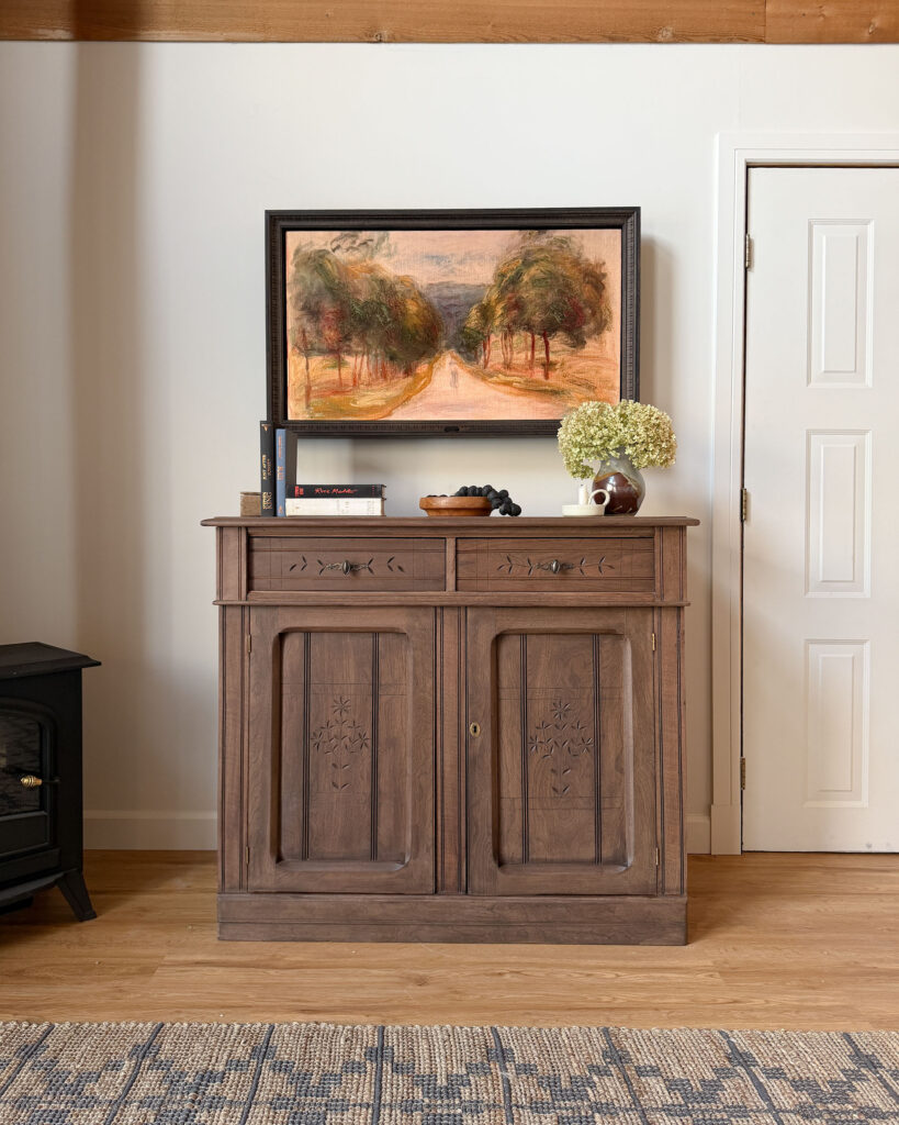 Framed TV over an antique piece