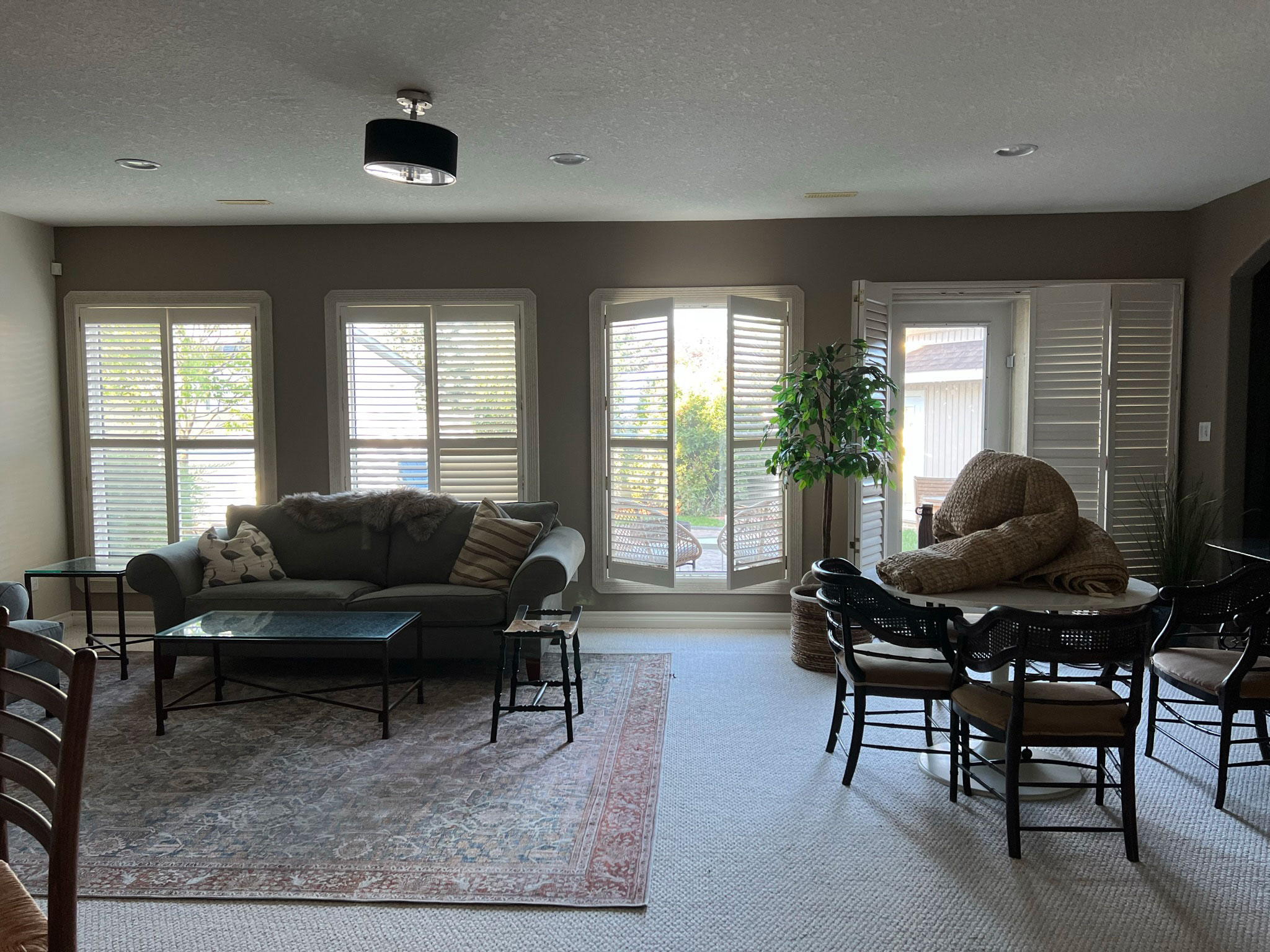 Rec Room before with table and chairs and a sitting area, wall of windows