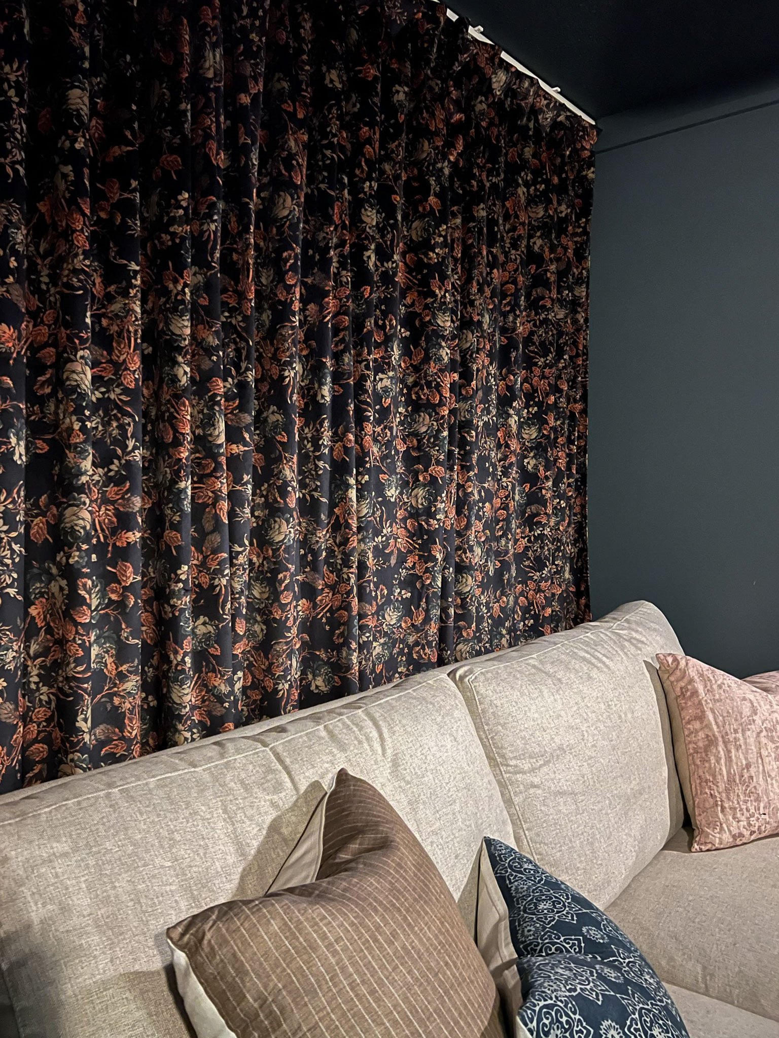 Media room black out floral curtains behind the couch