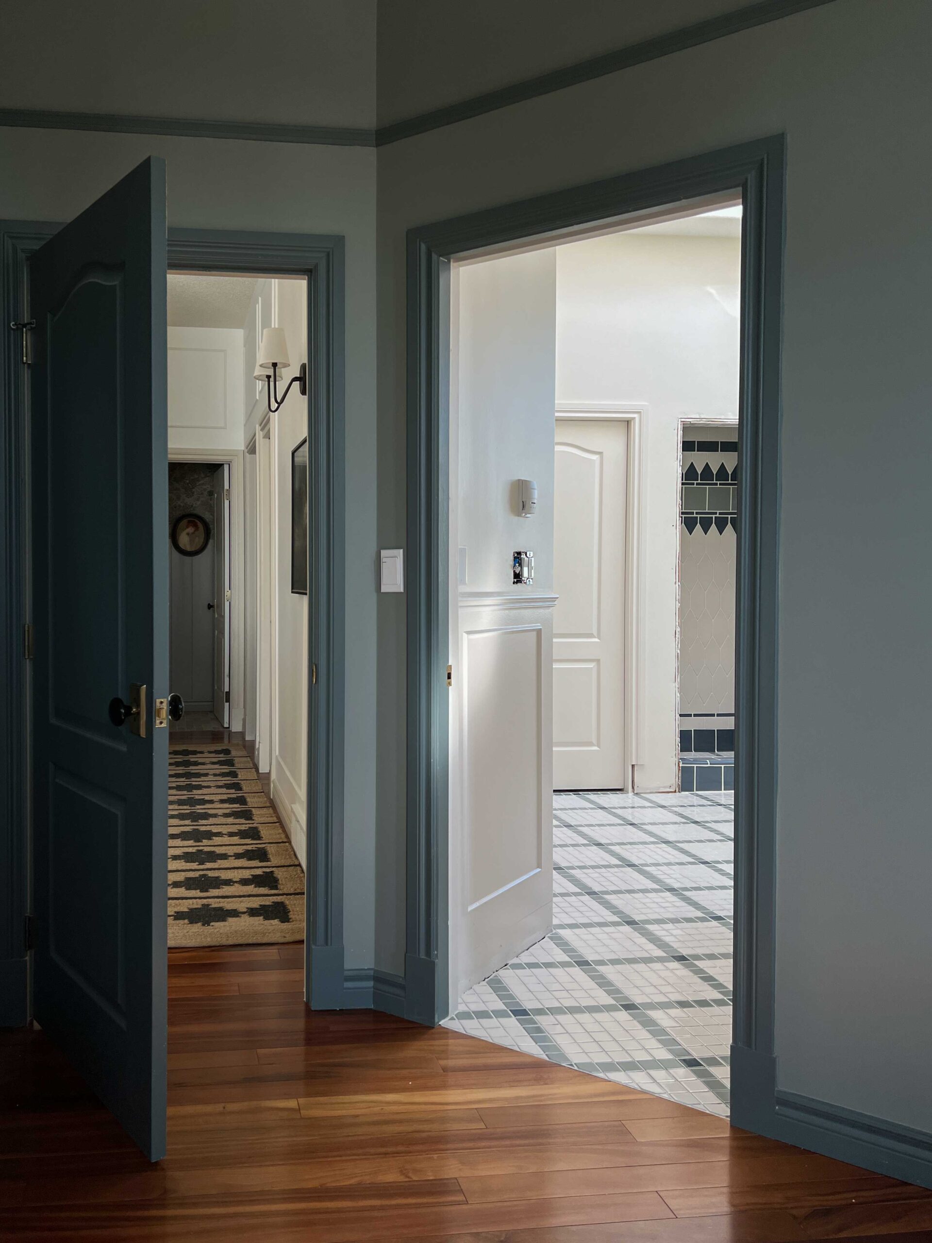 View through doorway into bathroom and hallway from blue bedroom