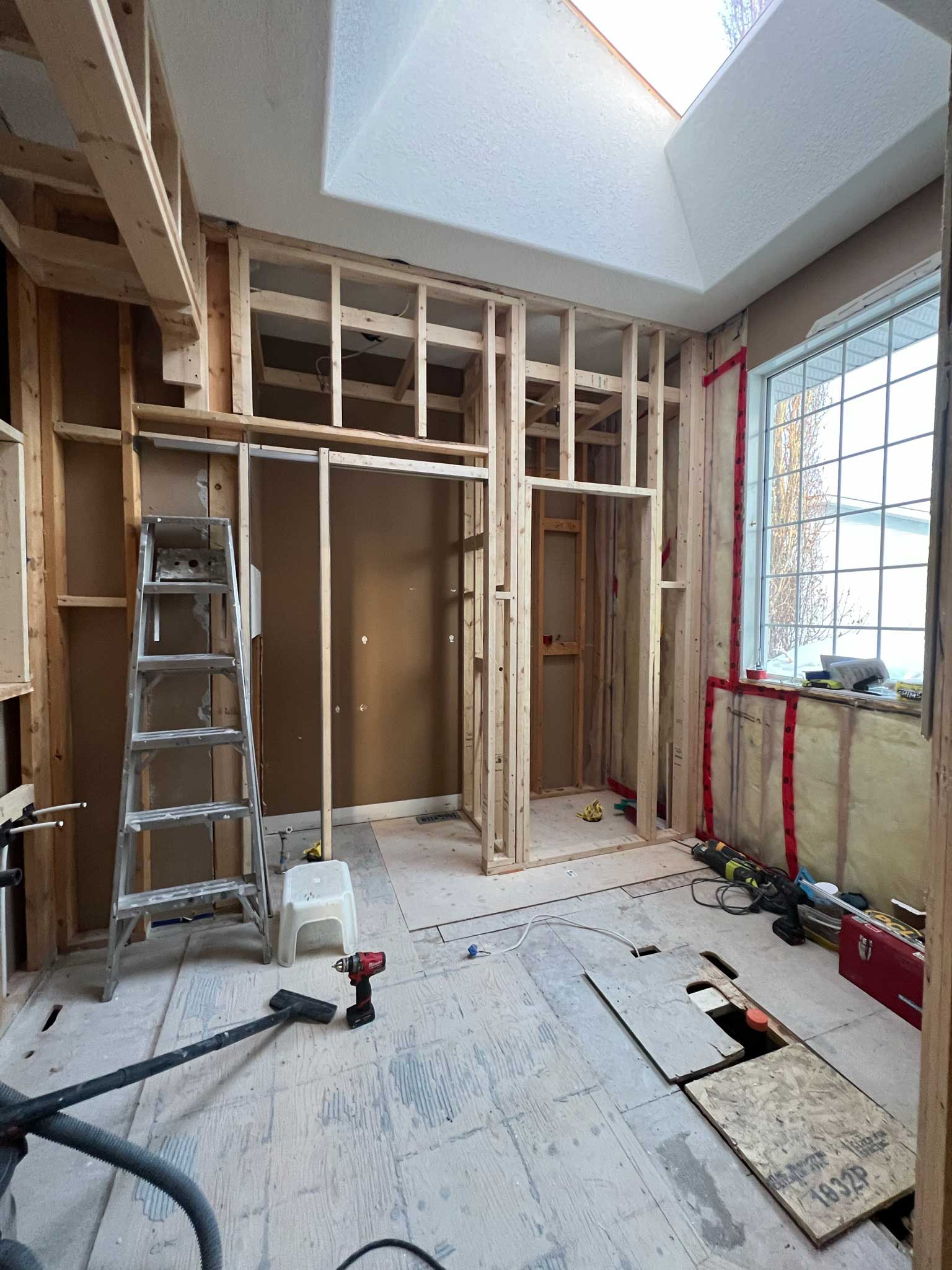 DIY bathroom makeover with room under construction with two doorways framed