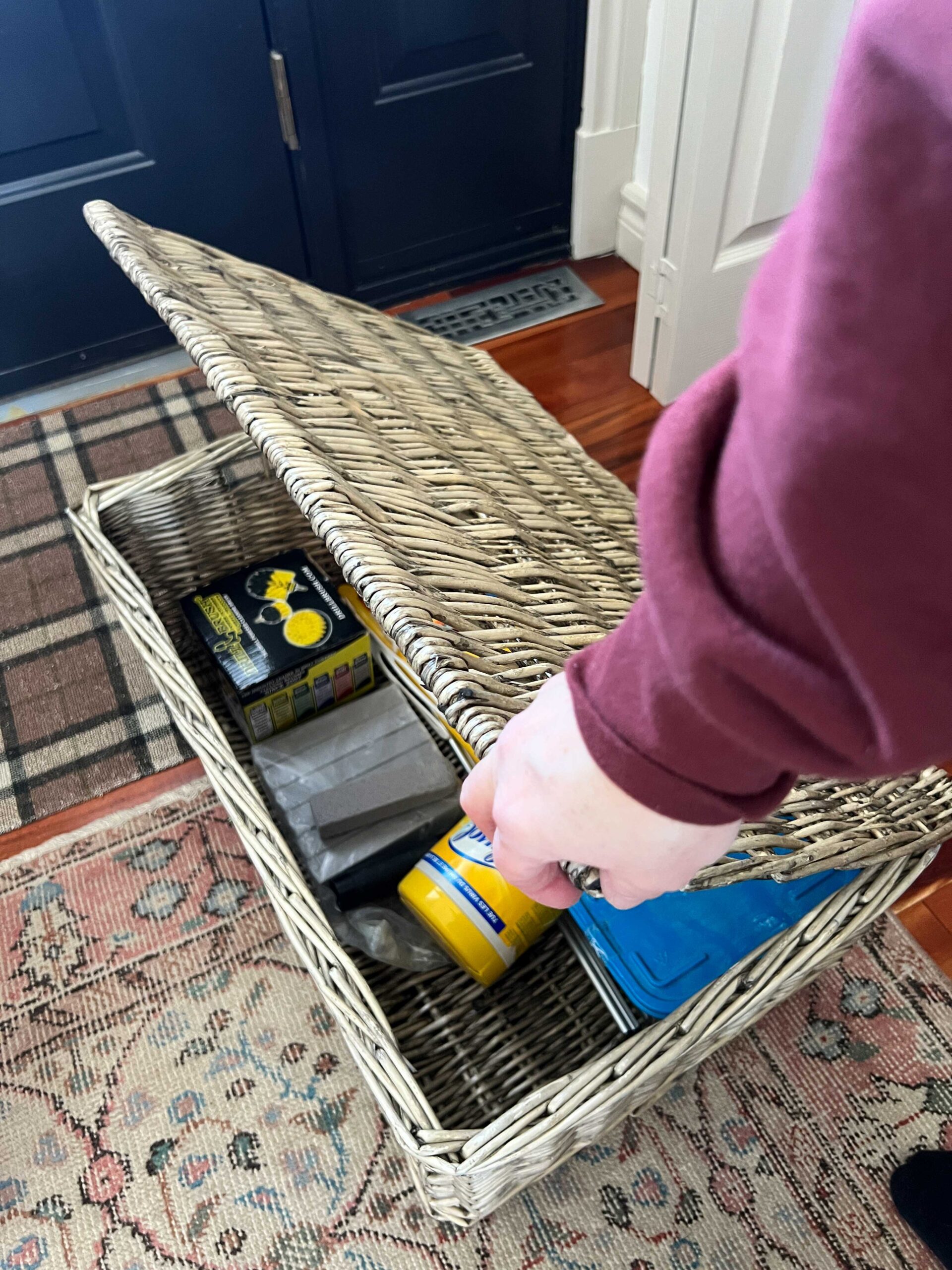 closing lid on basket with cleaning supplies inside