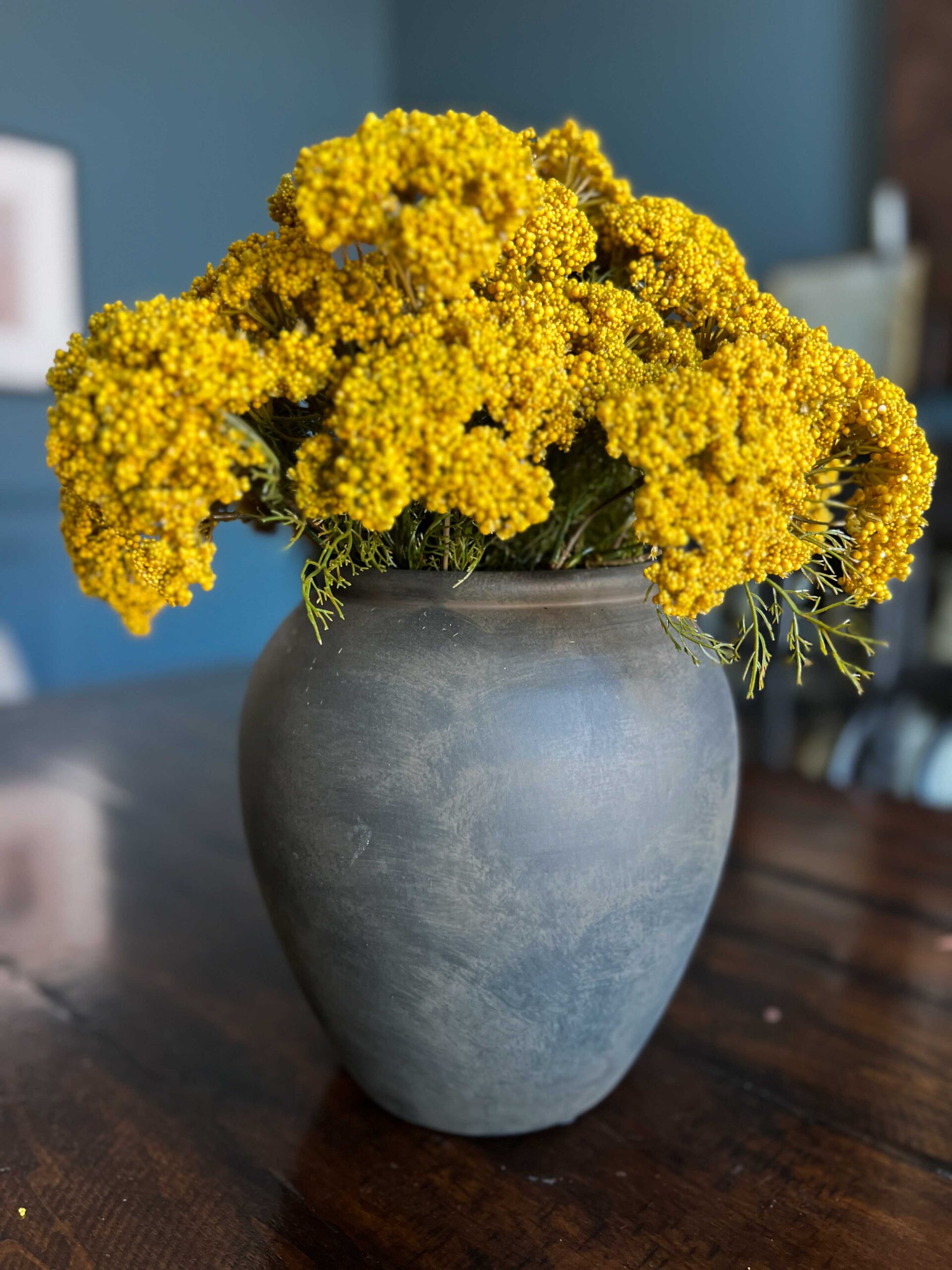 black vase with yellow flowers