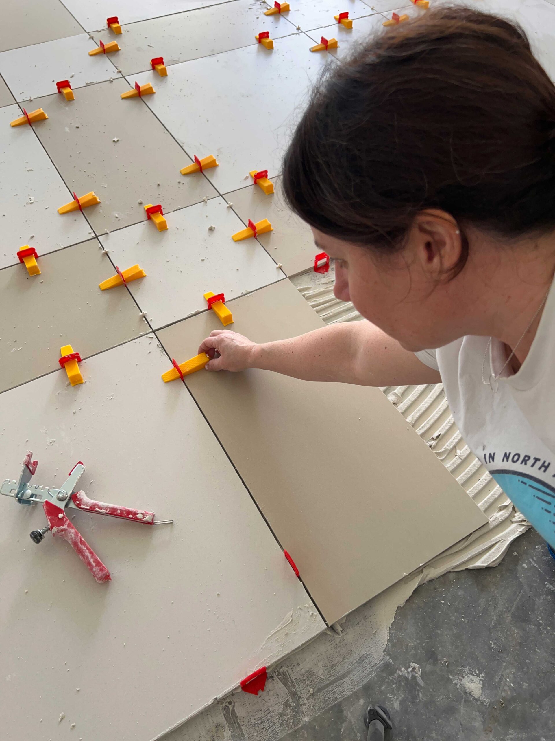 woman placing wedge in levelling spacer