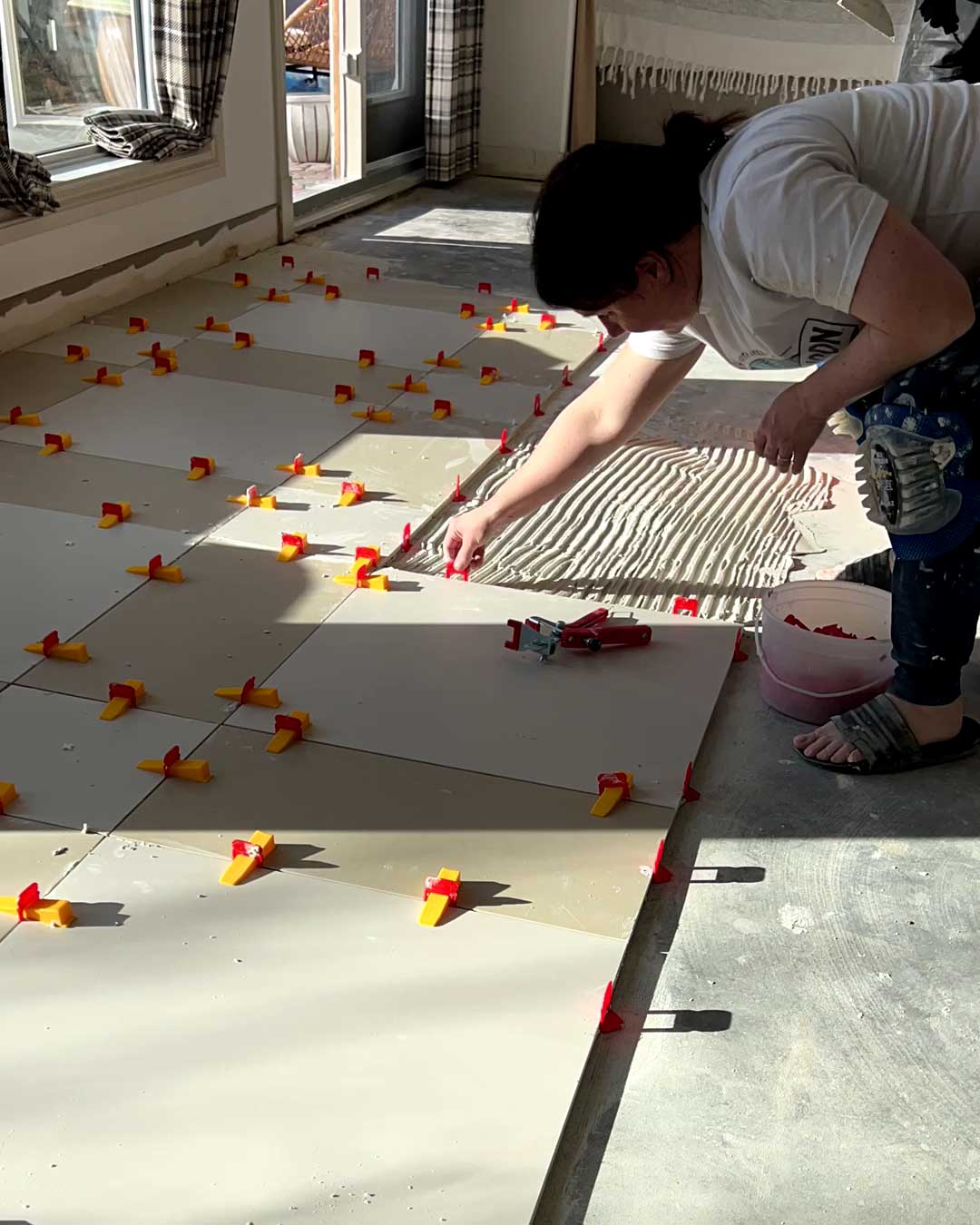 woman placing spacers in large format tile installation