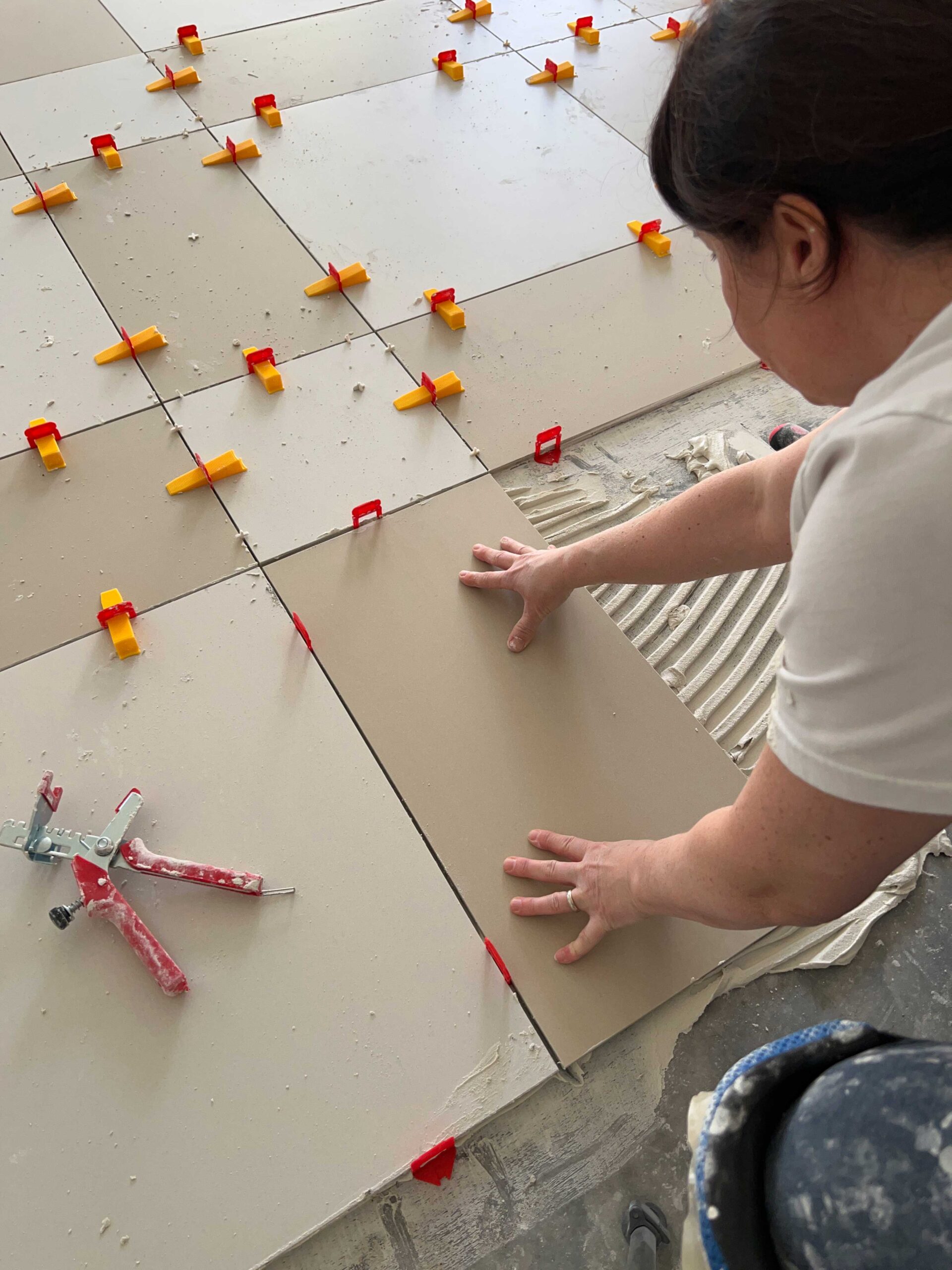 woman placing tile on the floor