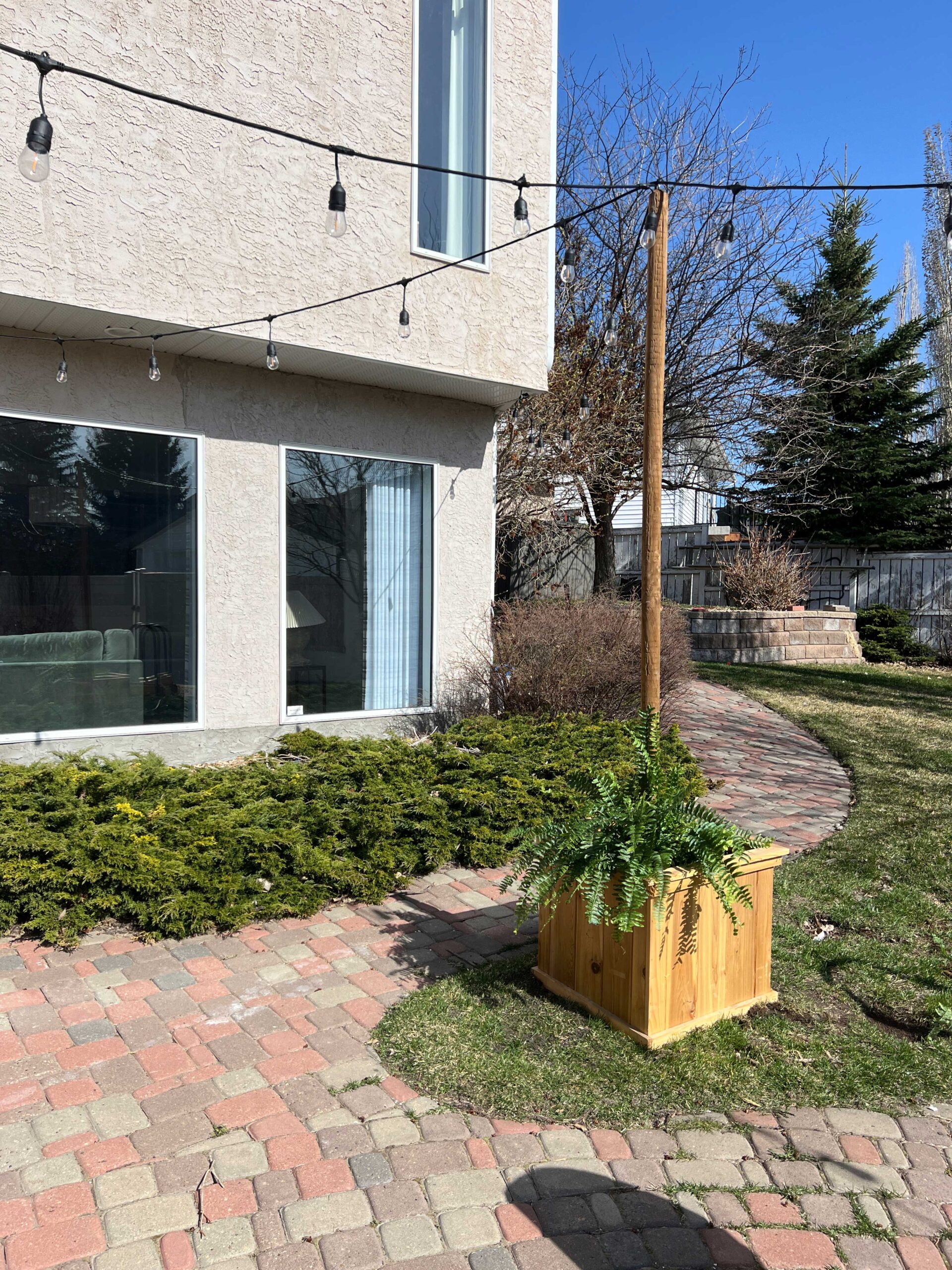 string light pole in planter with string lights attached