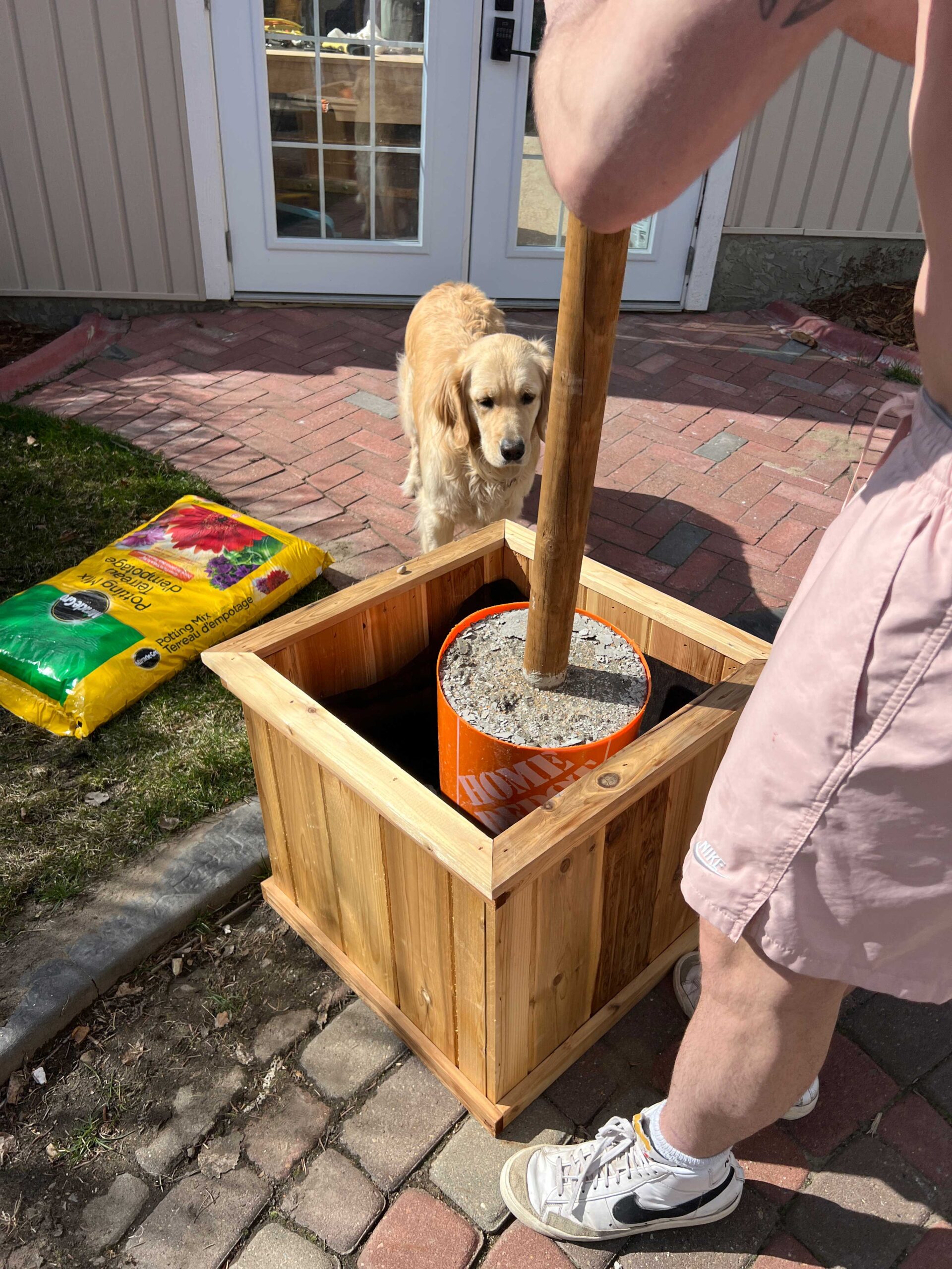 Placing bucket with concrete into planter