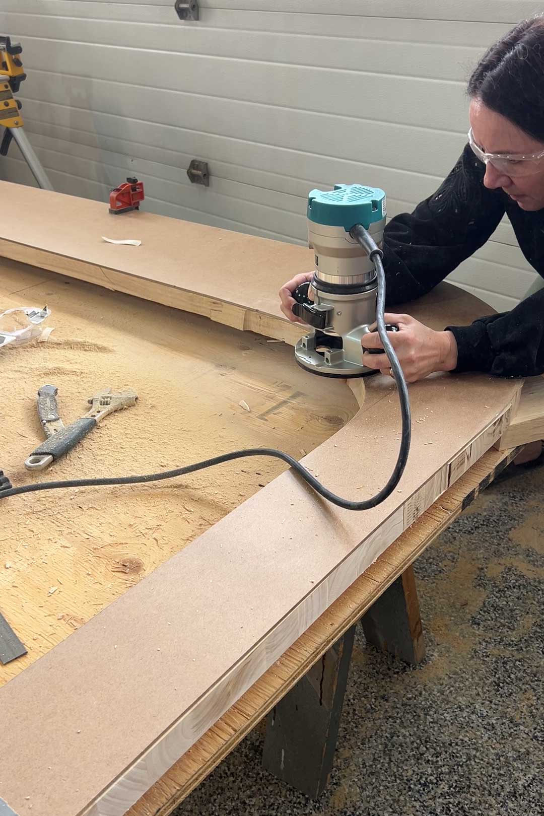 Cutting along the edge of the template with the router