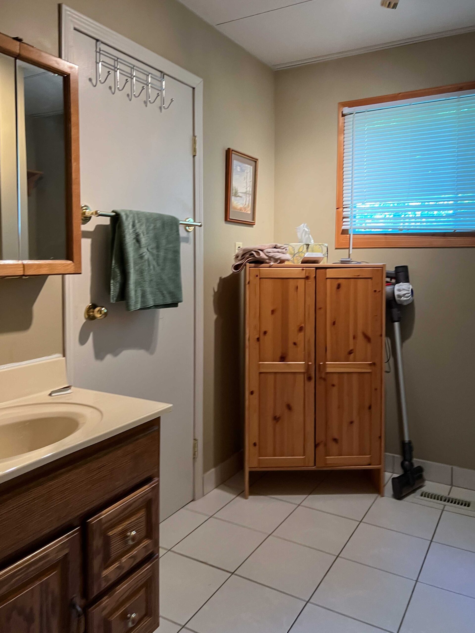 batrhoom with small vanity and freestanding cabinet