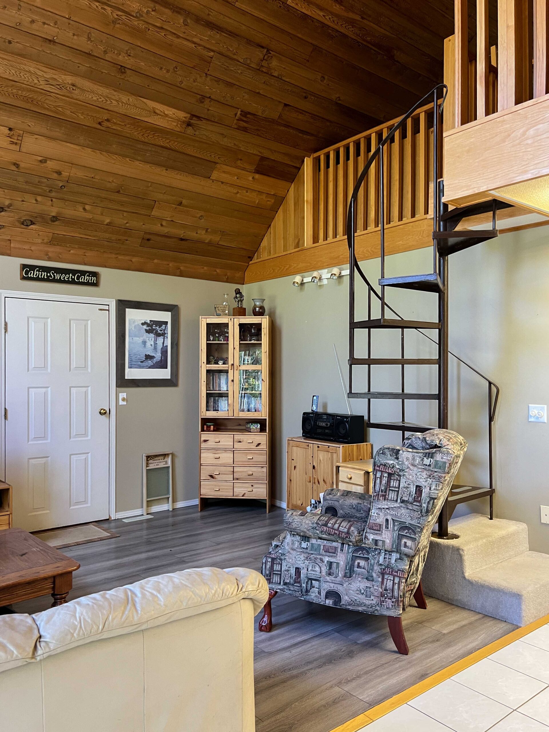 room with a spiral staircase leading to a loft and pine planked ceilings