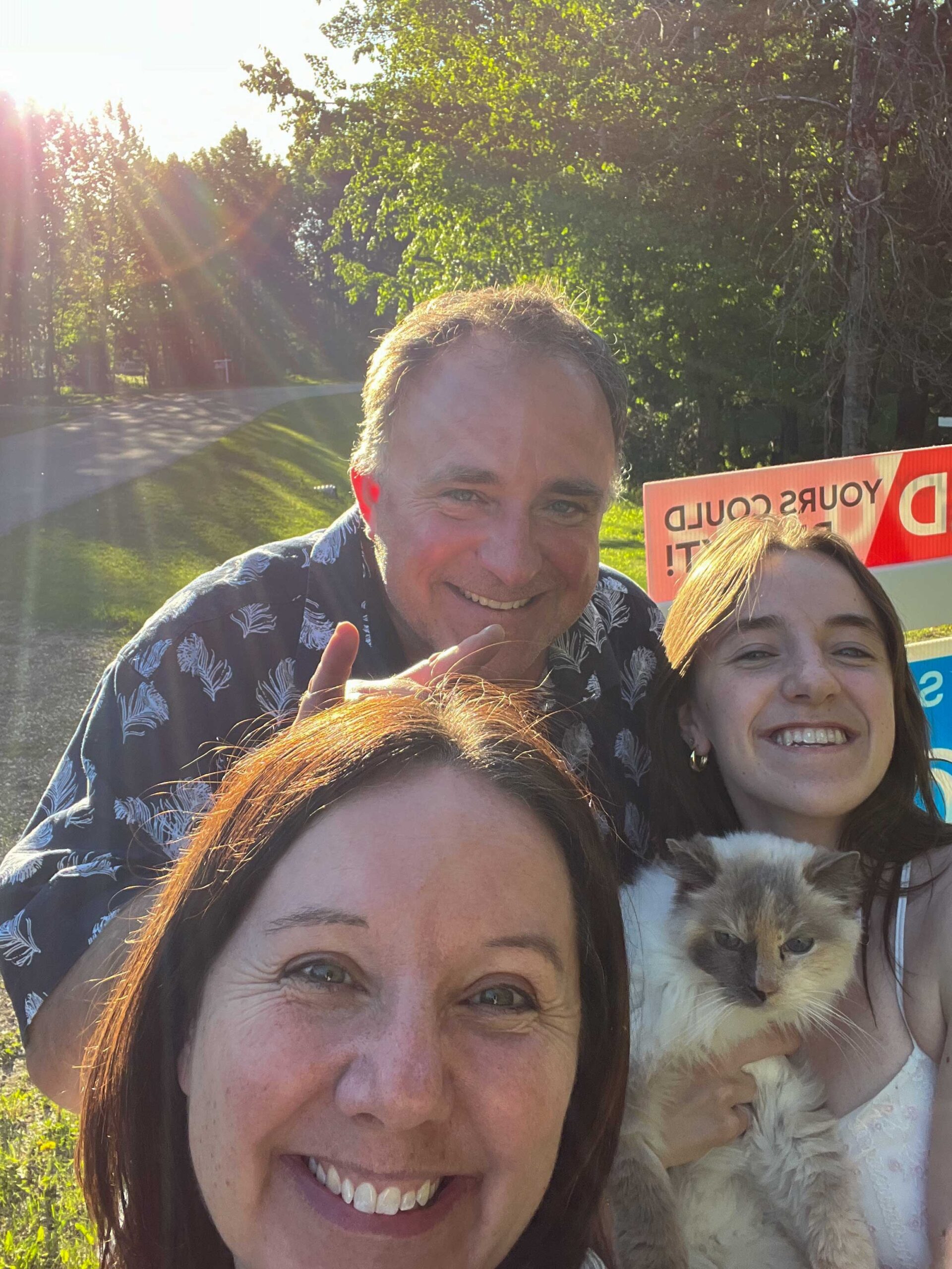 Selfie of three people and a cat
