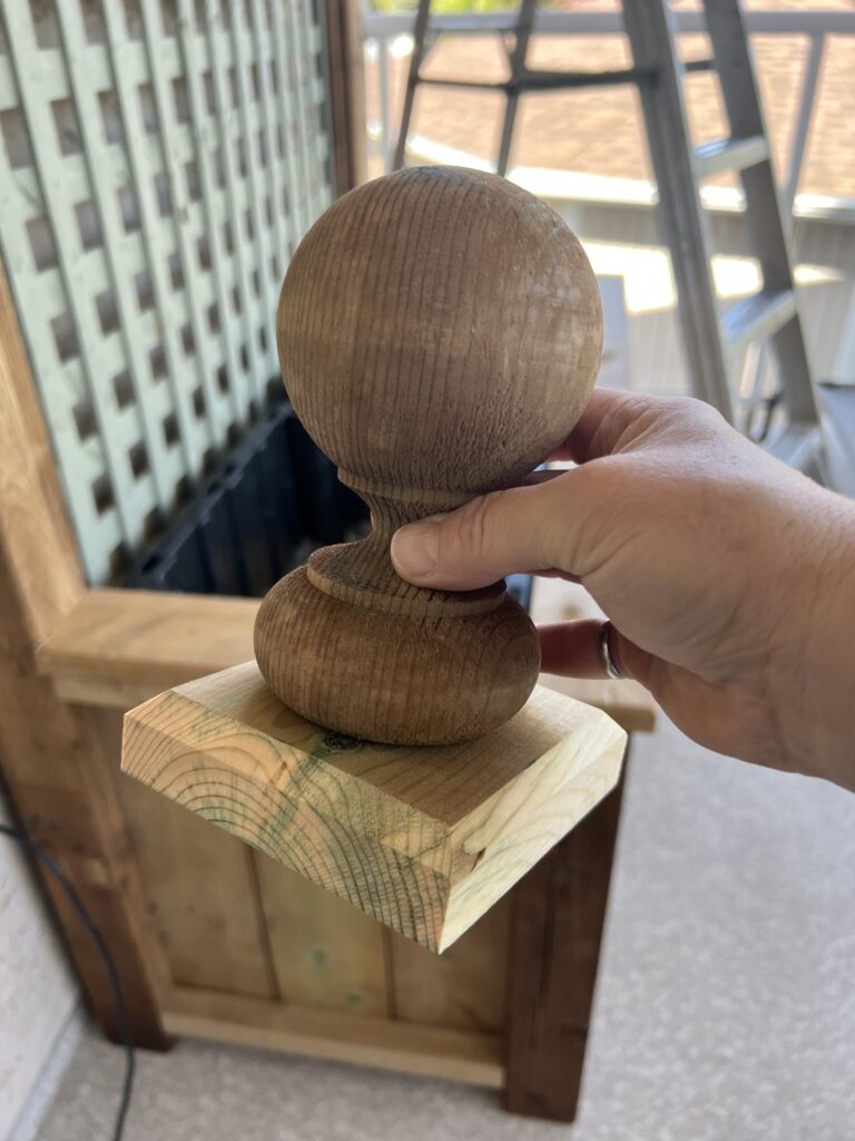 Erin is holding a fence finial attached to a post cap.