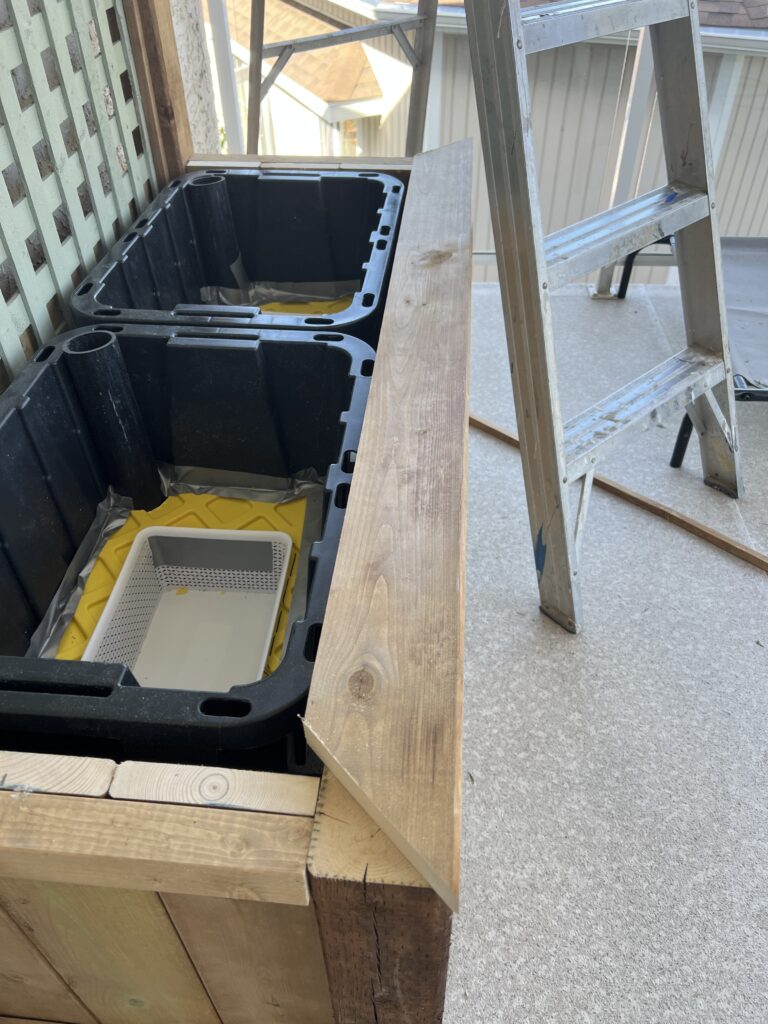 Deck boards are secured to the top of the planter to give a finished look.