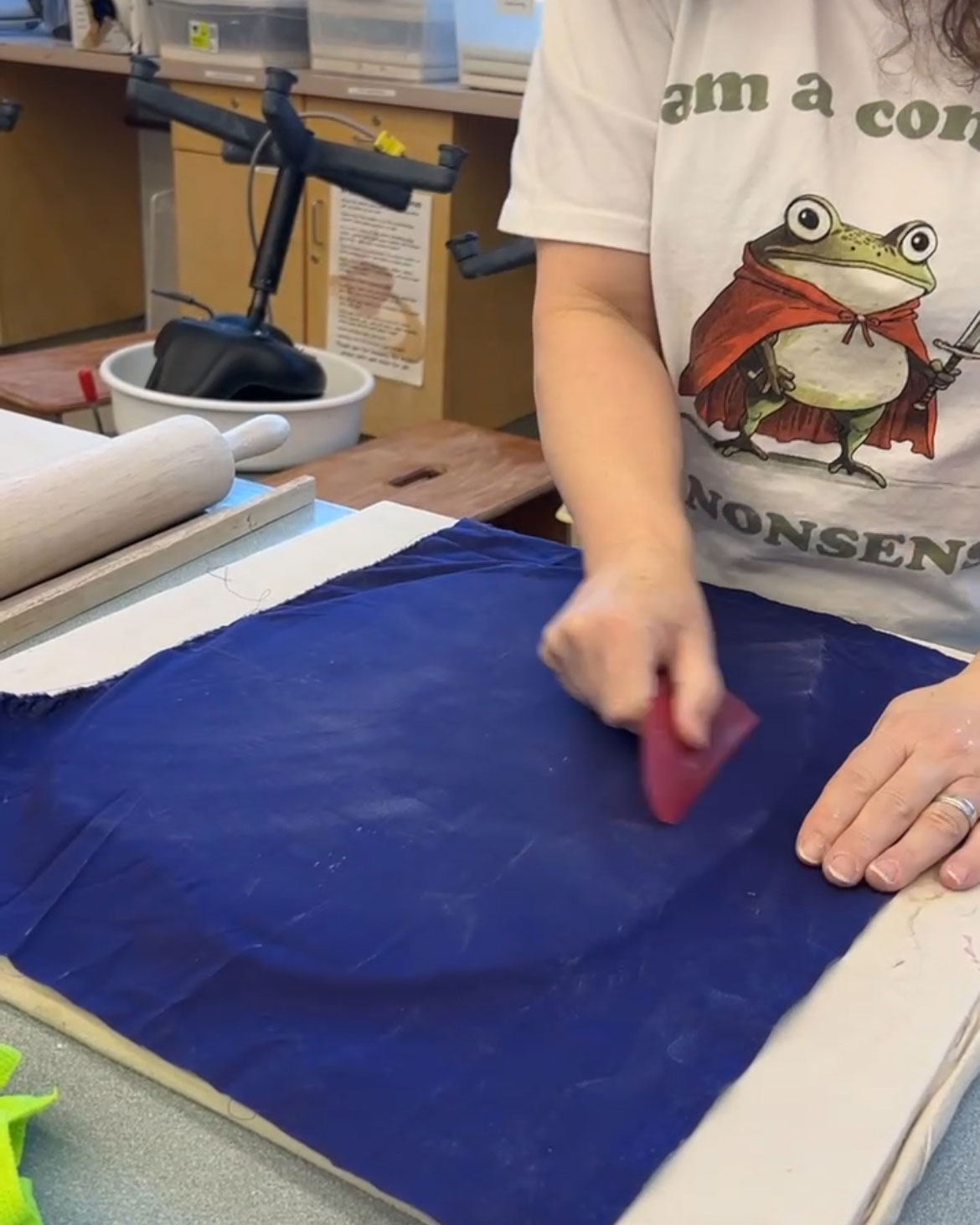 Compressing clay using a by running a tool over the rolled out clay covered in cloth