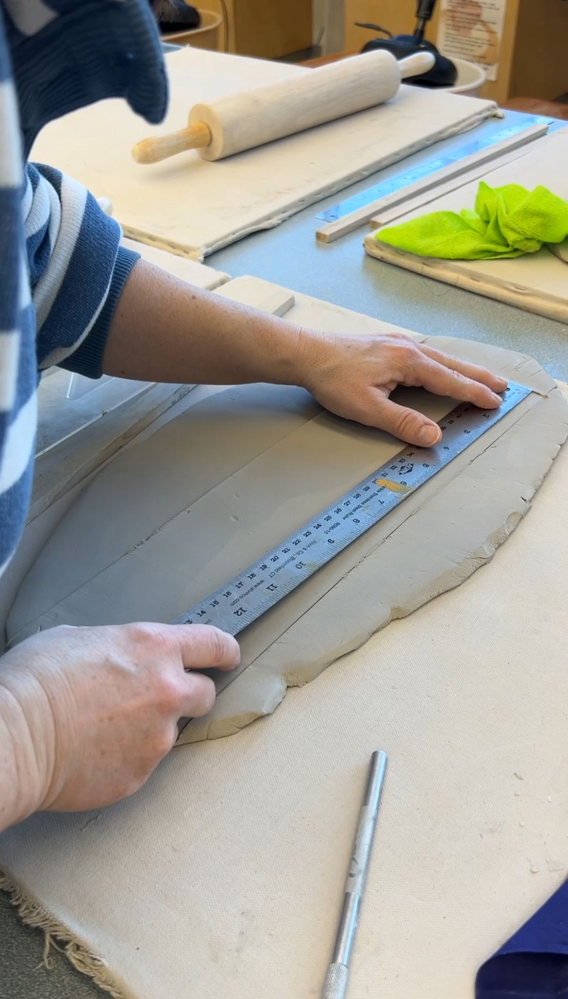 Using a ruler and knife to cut a straight line down the tile