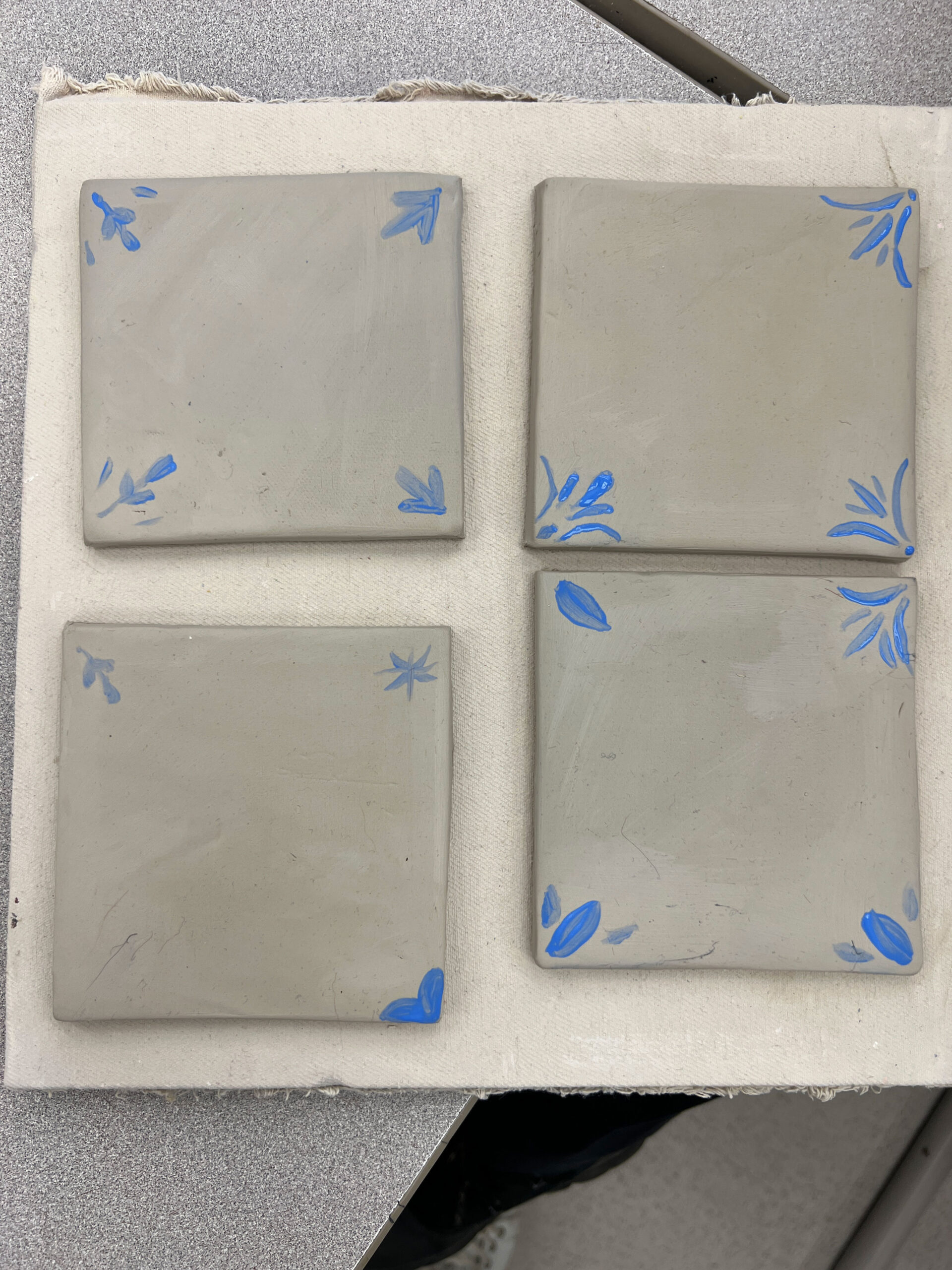 four square tiles with different corner designs