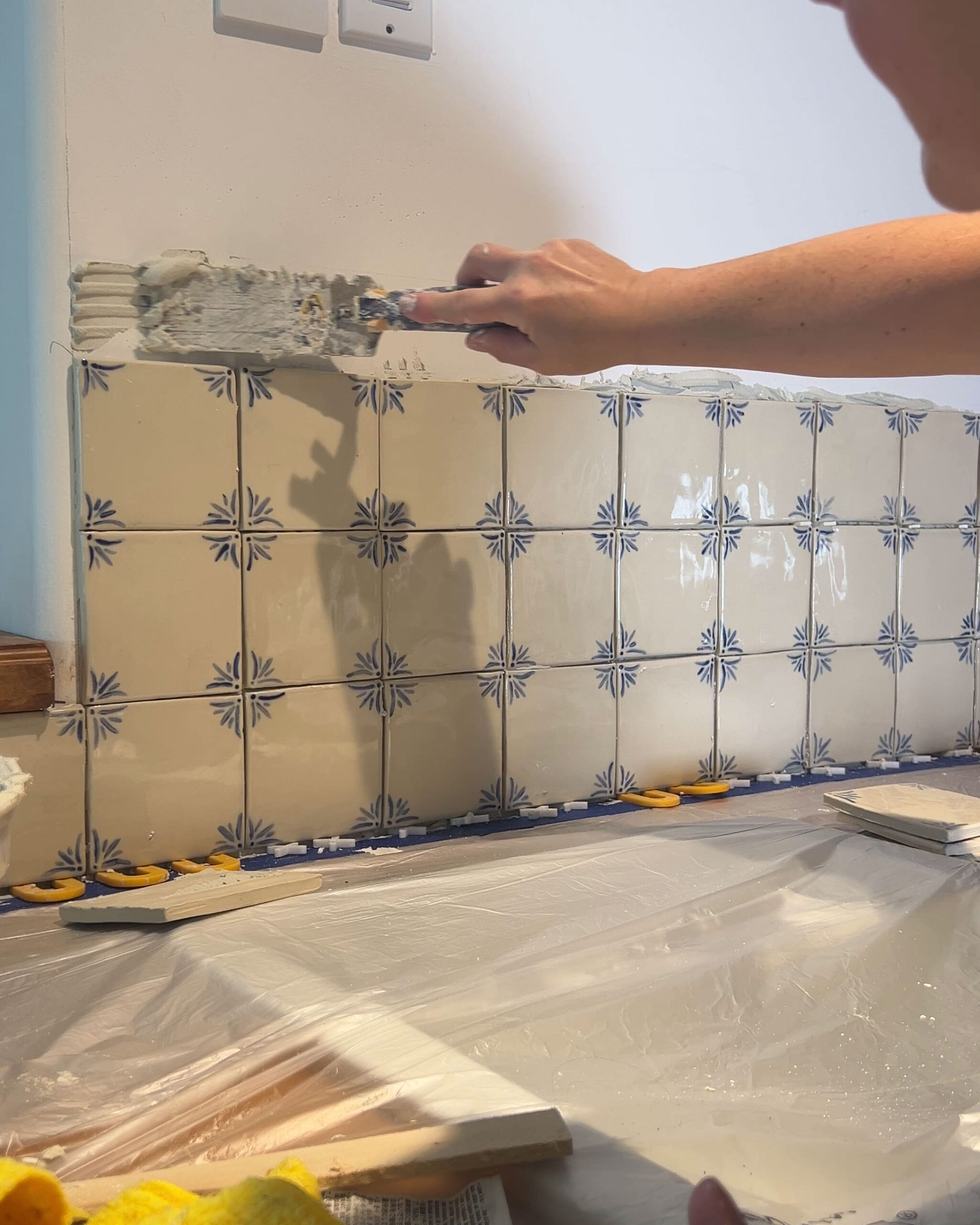 spreading mortar on the wall above the top row