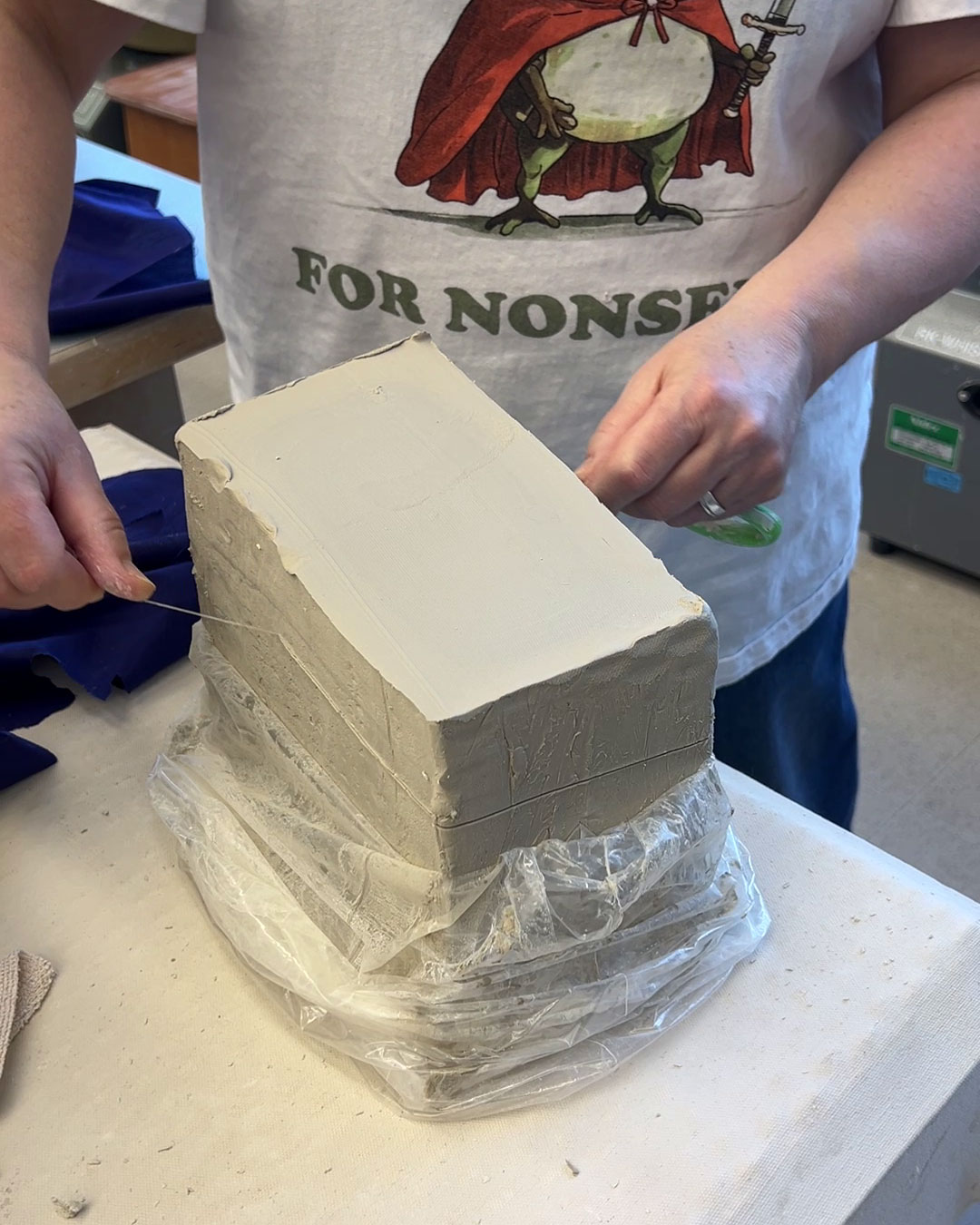 Cutting a block of clay with a wire cutter