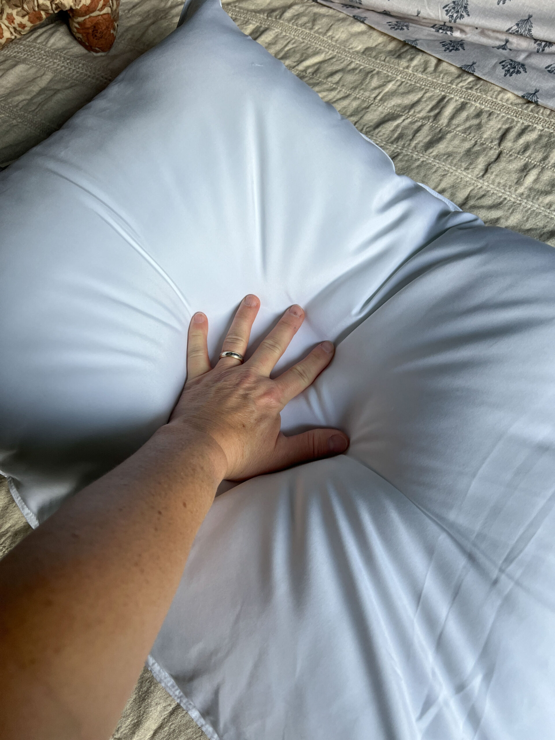 hand pushing down into a plush pillow