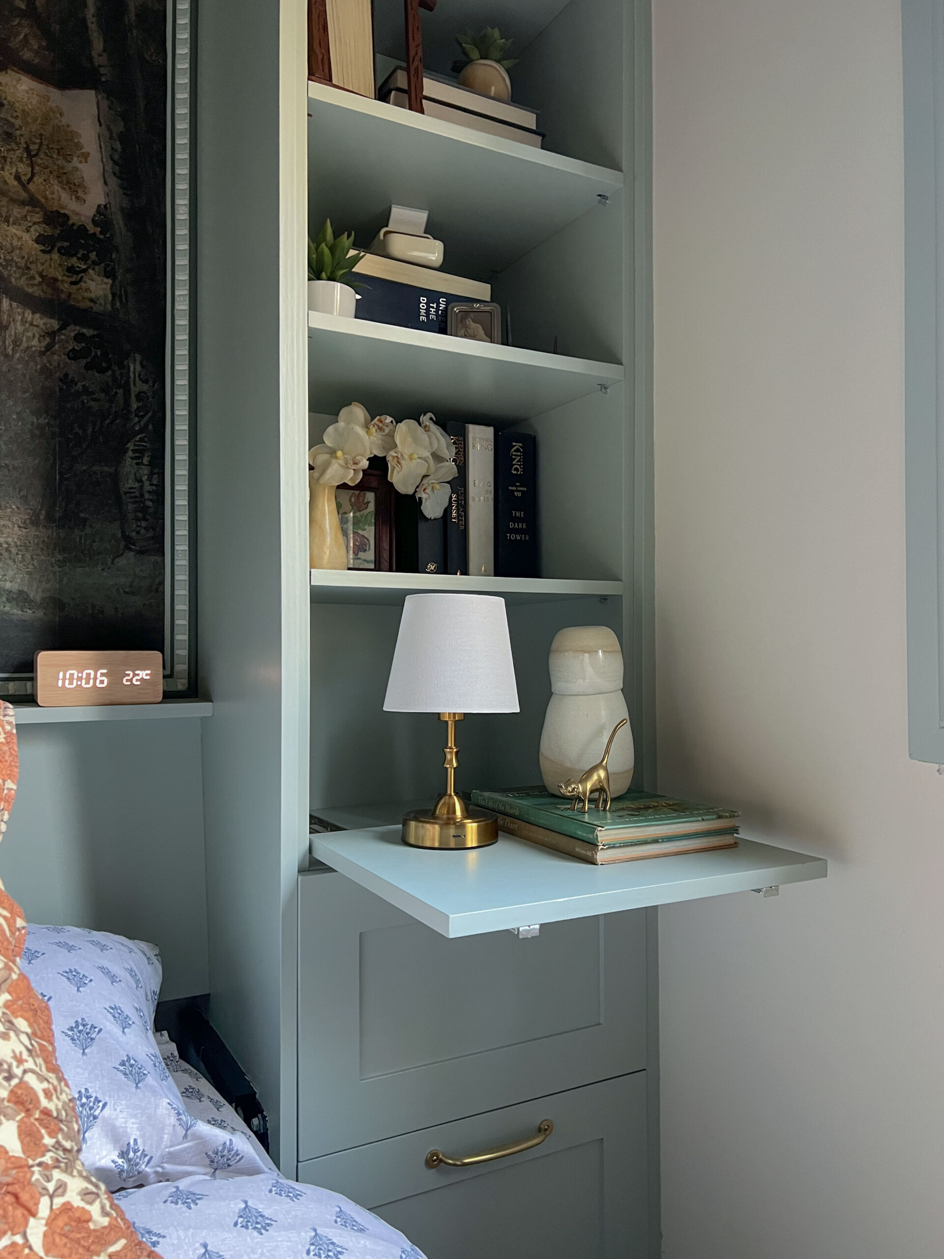 bed built in with bookshelves to the side and a side table tray pulled out.
