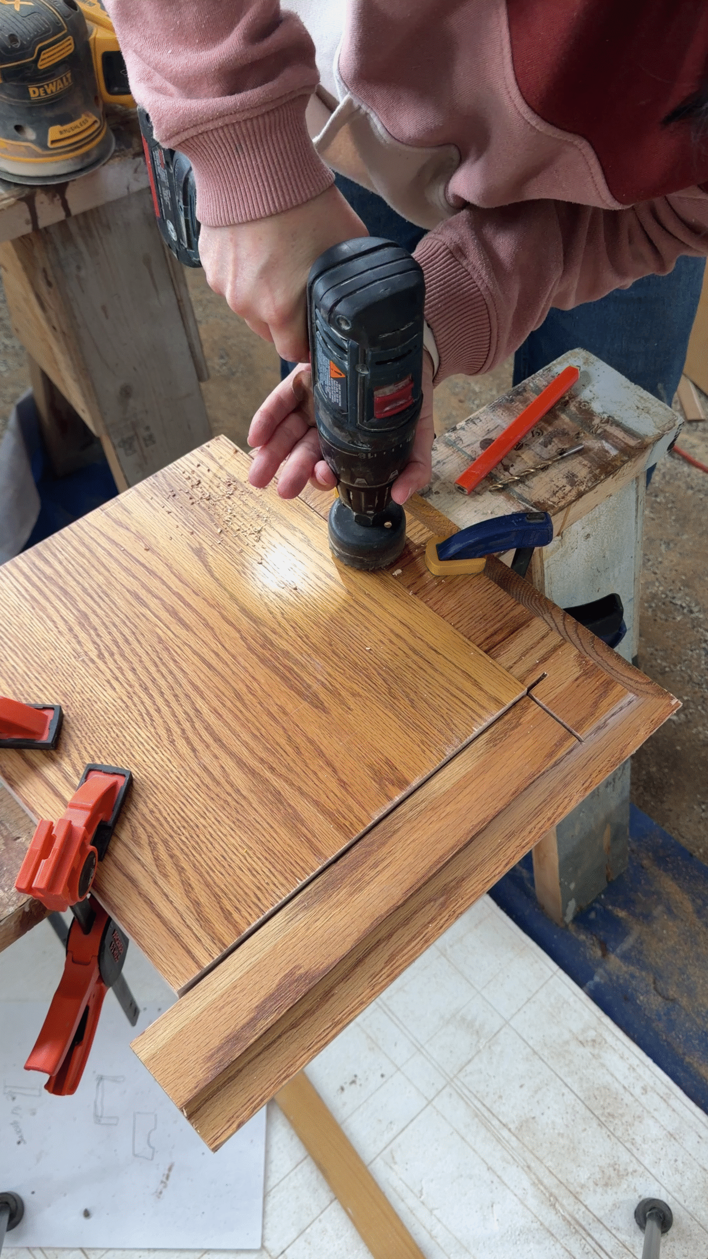 Cutting a round finger pull into the top of a drawer.