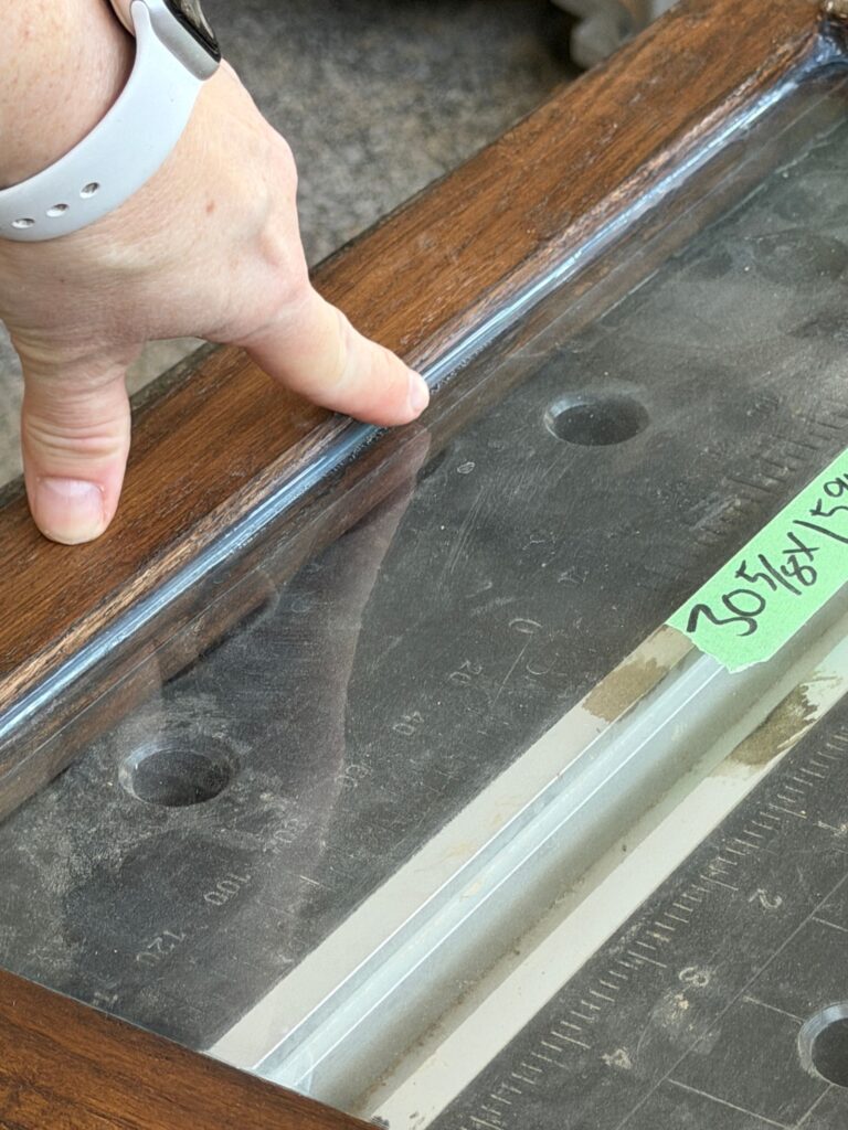 Adding glass to the doors of the DIY coffee bar using silicone to hold the glass in place.