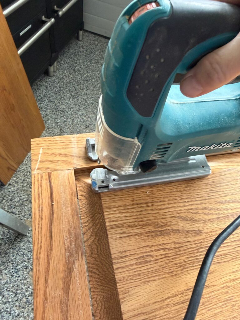 Using a jigsaw to cut the corner of the panel.