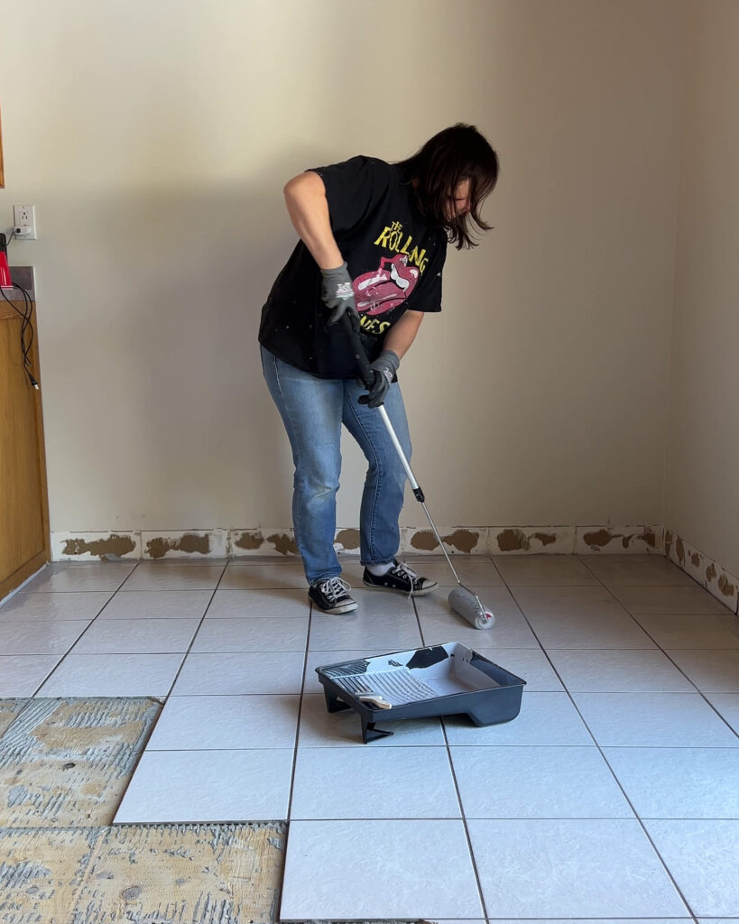 Putting a primer down on top of tile to prep the floor