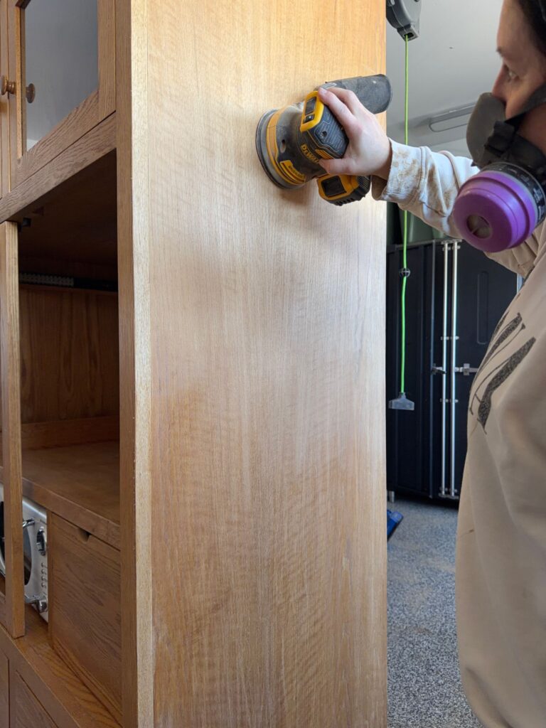 Sanding the outside of the armoire.