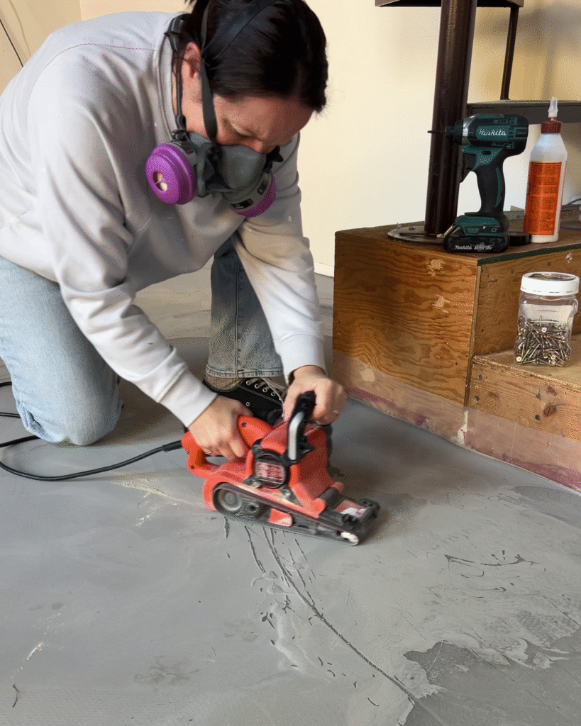 Fixing high spots in the self levelling concrete with a belt sander