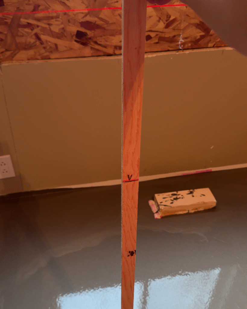 Using a stick to measure the level of the concrete