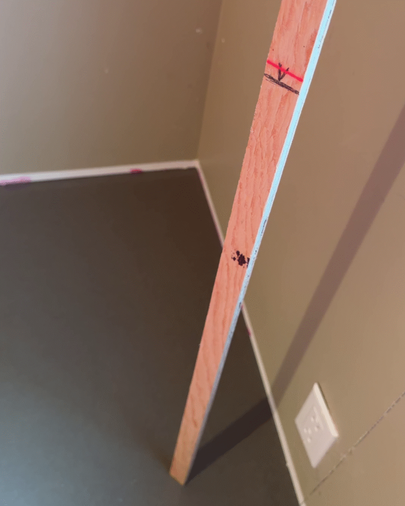 A stick marked with the proper level held to the surface of the concrete for measuring