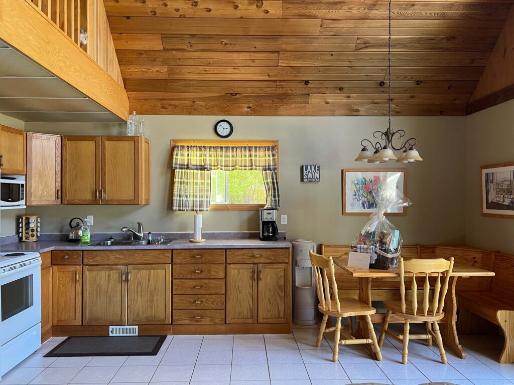 kitchen with built in nook on the right, wood cabinets, white tile, wood ceiling