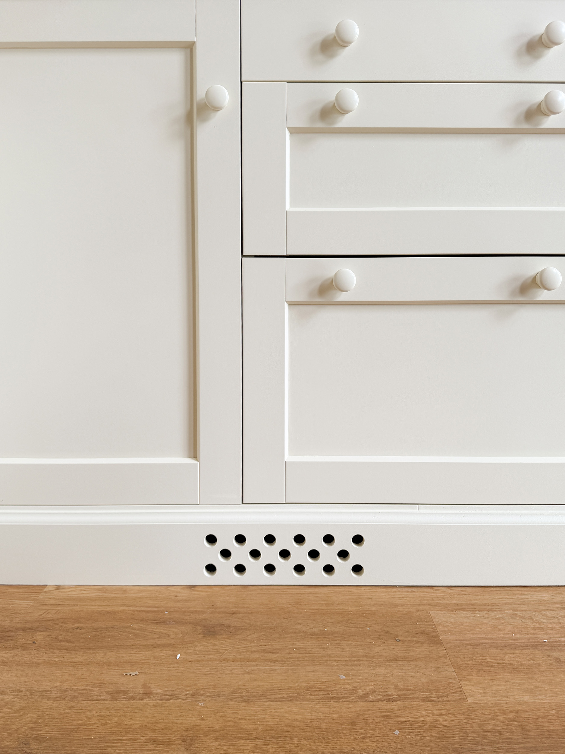 cabinet with a baseboard furniture style toe kick and holes for a vent
