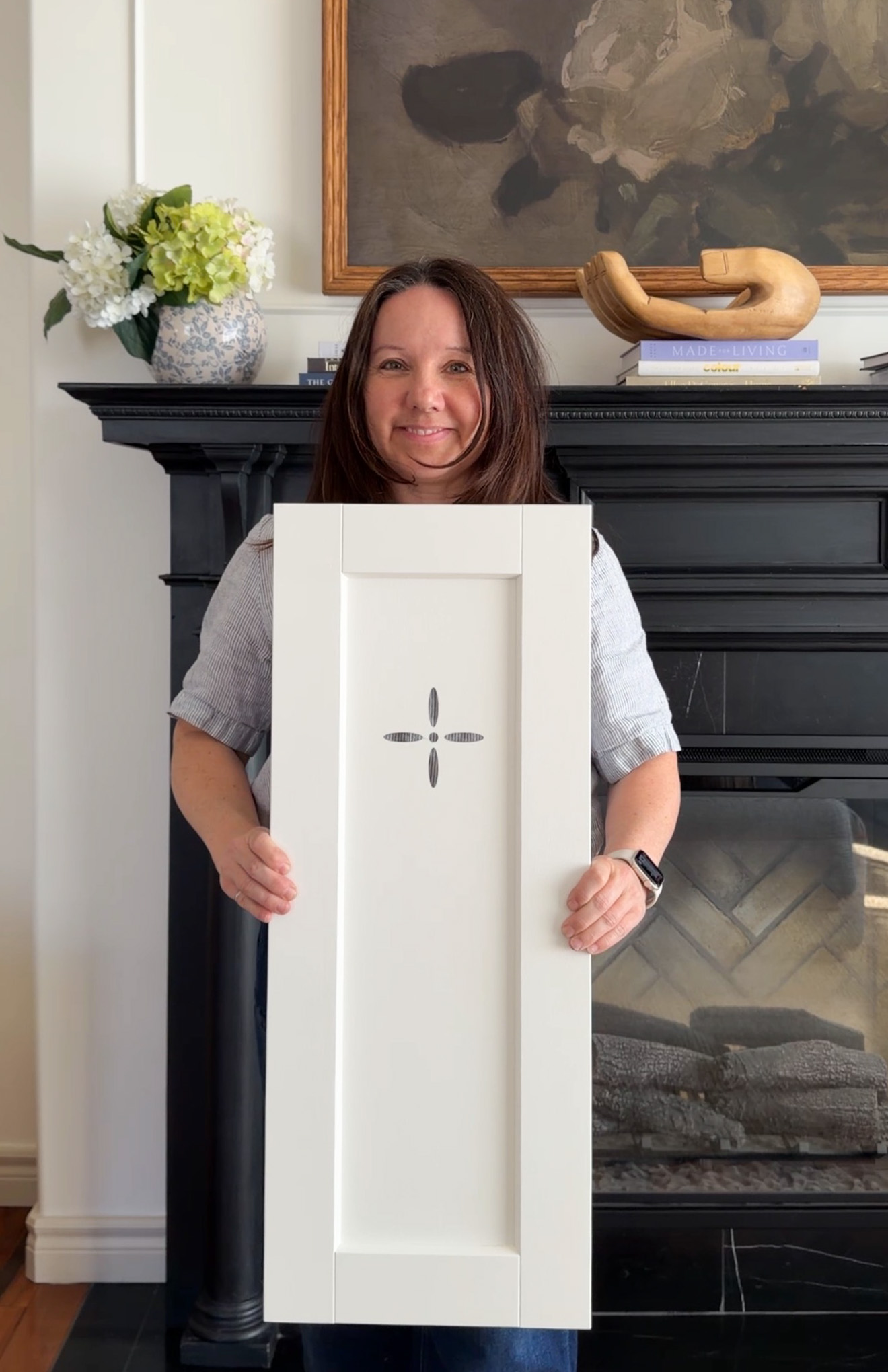 girl holding a cabinet door with a flower shaped cut out in it