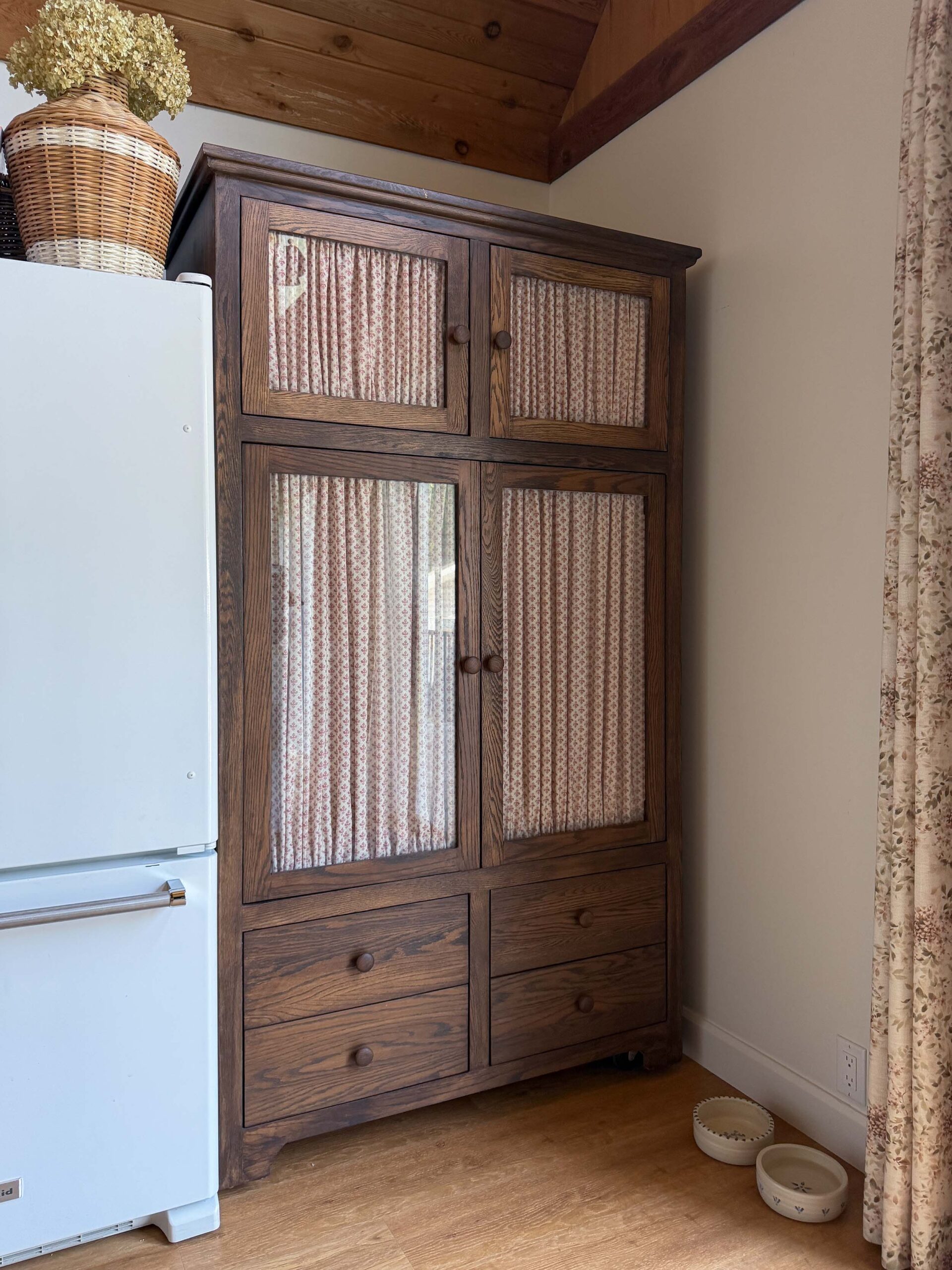 TV armoire turned into a pantry with glass doors and fabric