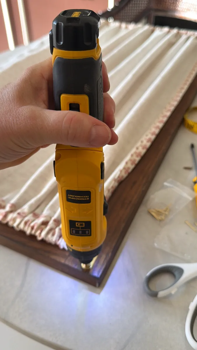 using an electric screwdriver to screw in a rod to a door